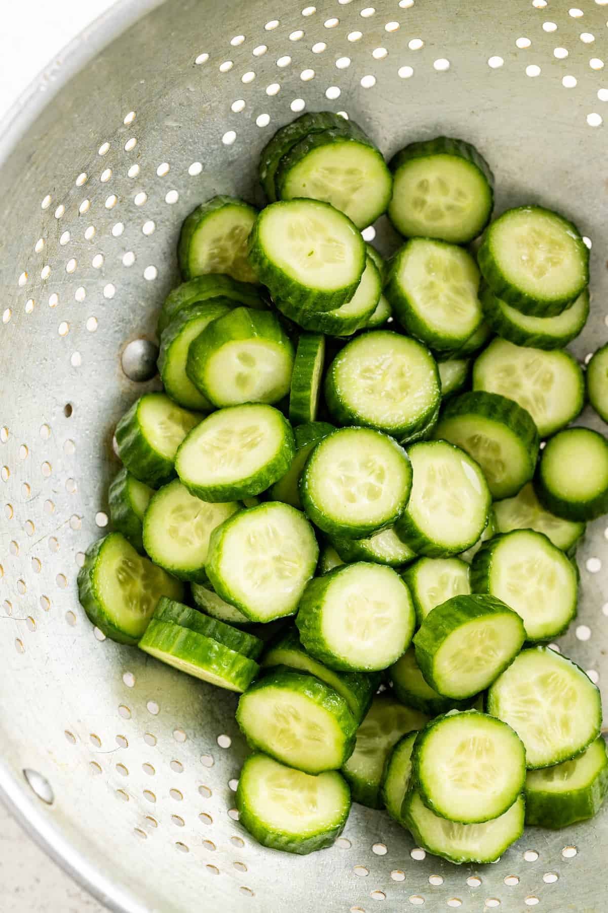 Straining the rinsed cucumbers.