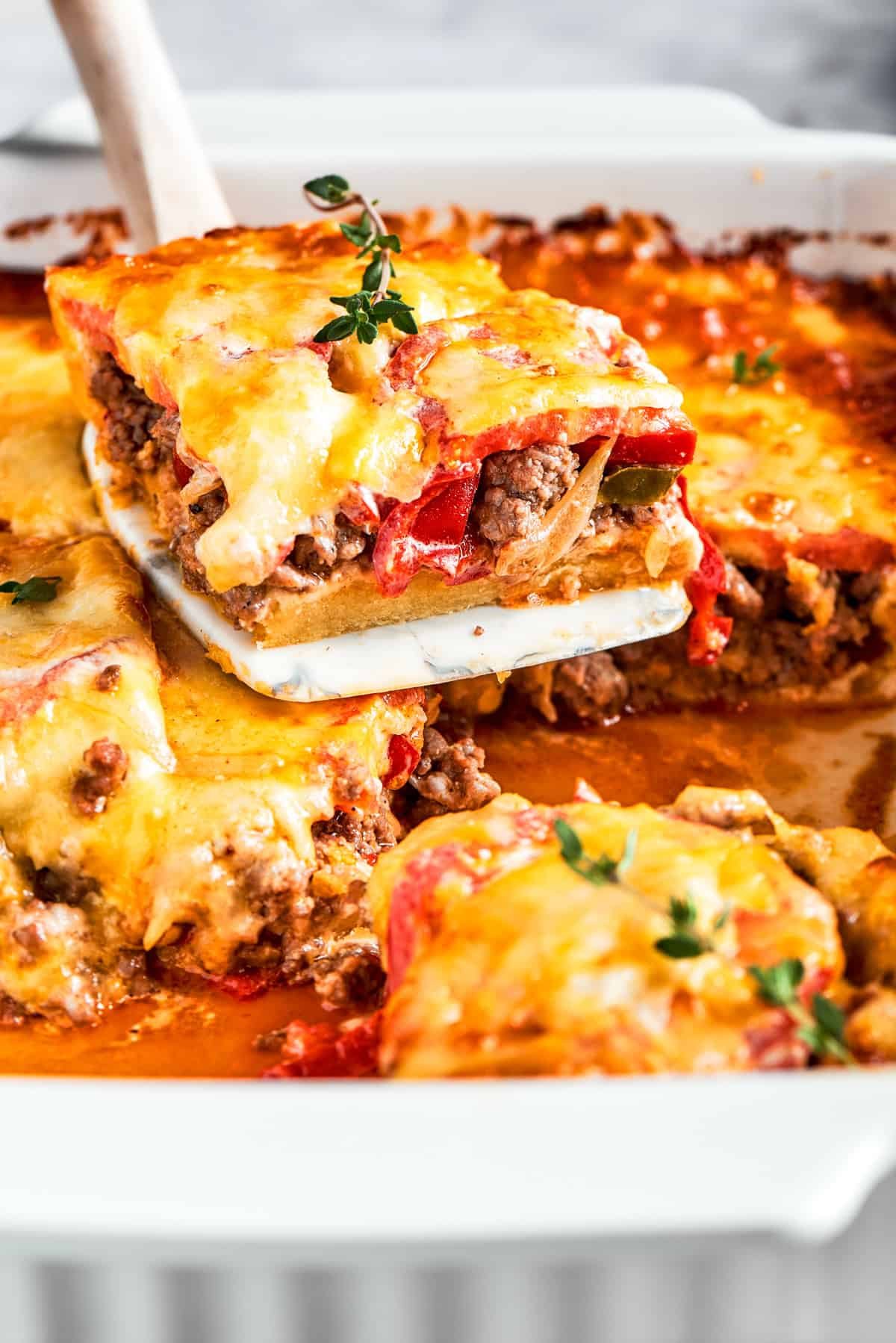 A slice of John Wayne Casserole being lifted out of the baking dish.