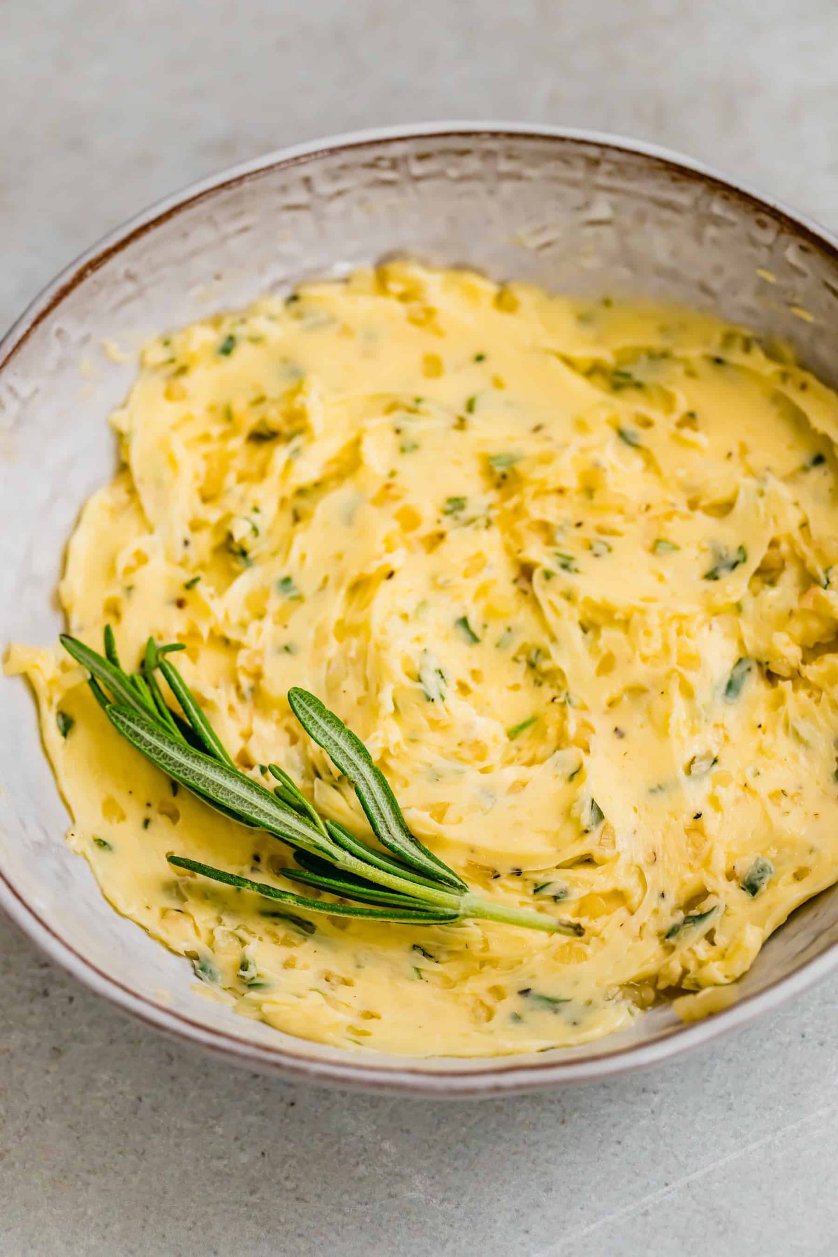 Bowl with butter and rosemary mixed together.