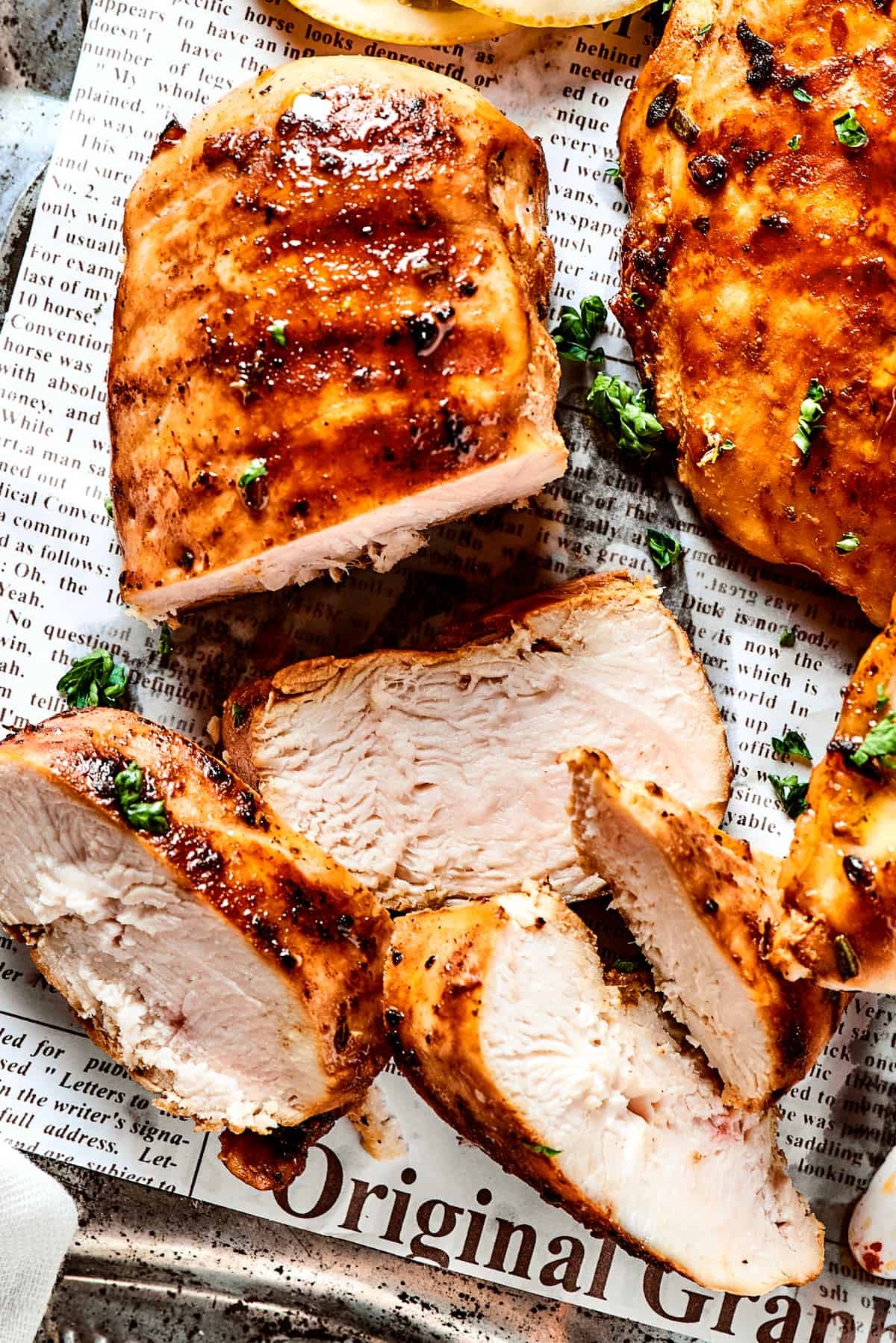 Sliced, cooked chicken breast on a tray.