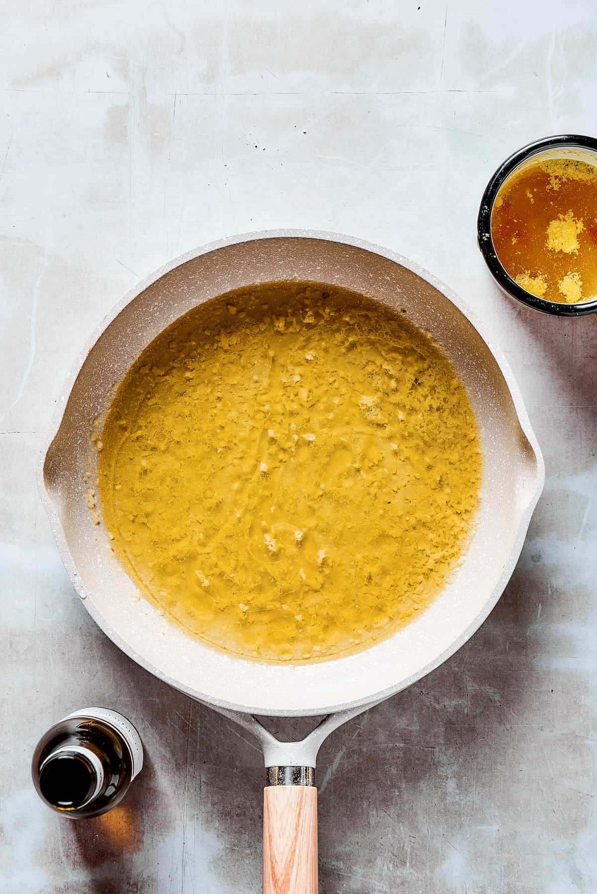 Broth and wine added to a skillet.