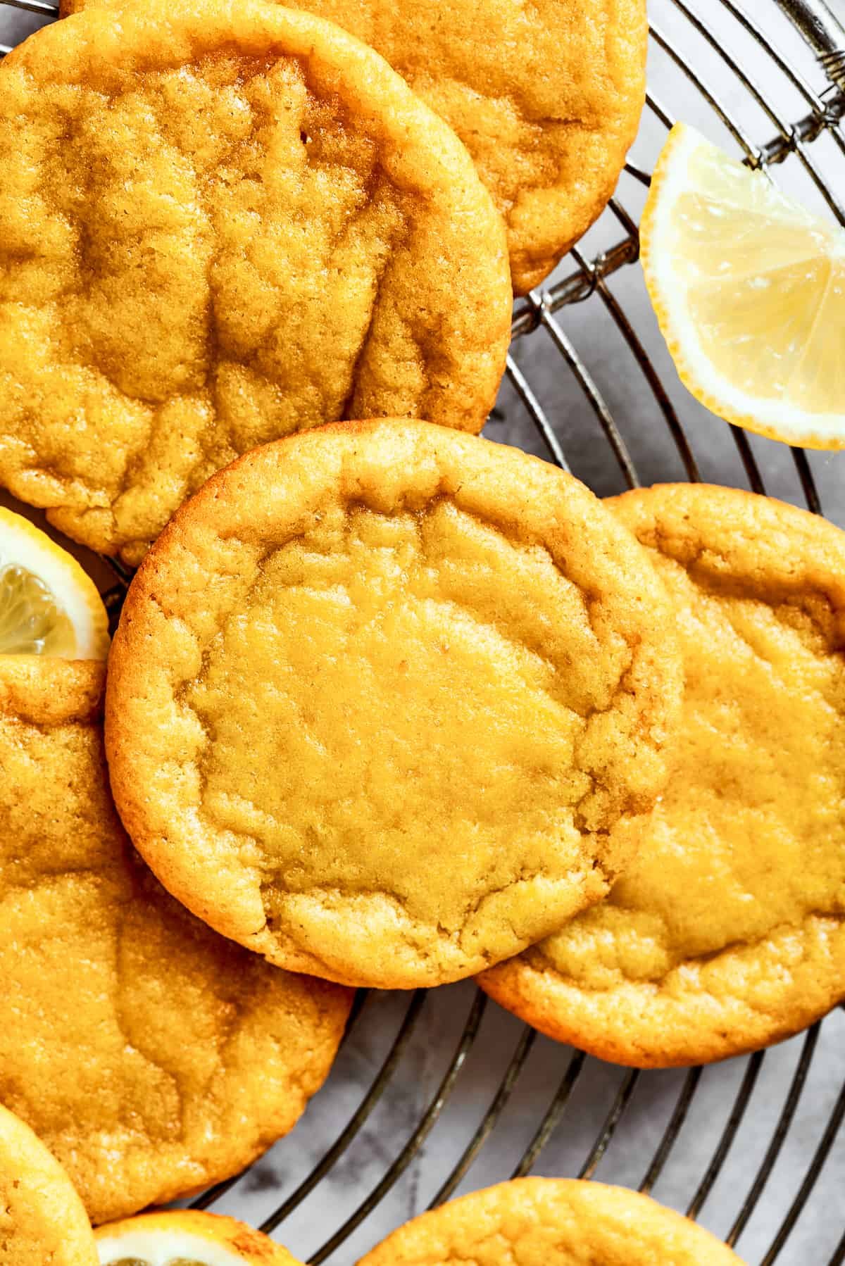 Close-up shot of several lemon cookies arranged on a round wire rack.