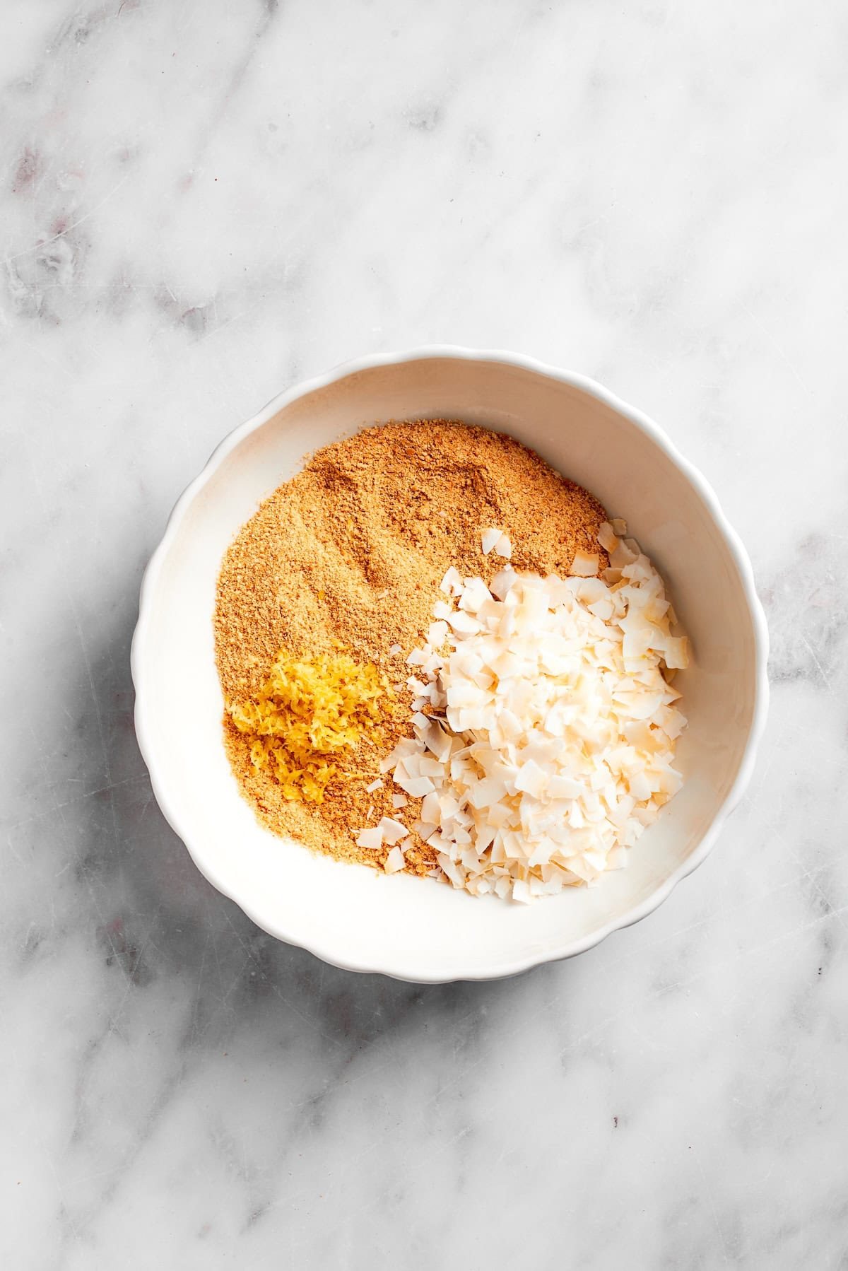 Coconut flakes added to crushed graham crackers.