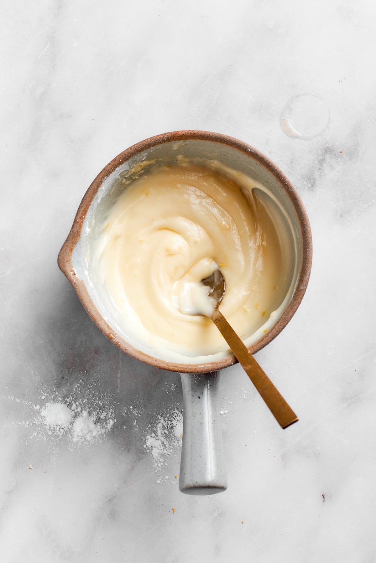 A spoon stirs a pot of lemon slice filling.