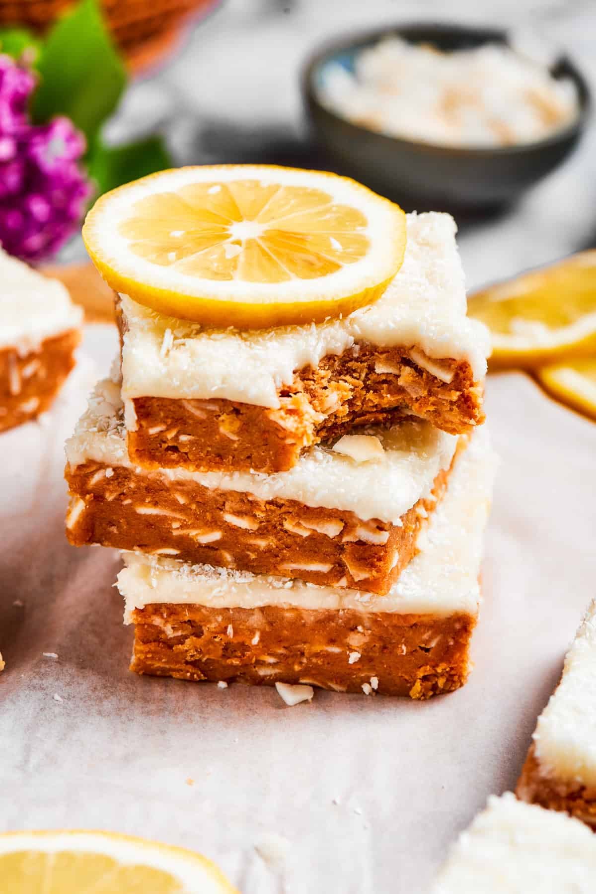 Three lemon slice squares, stacked, with the top one missing a bite.
