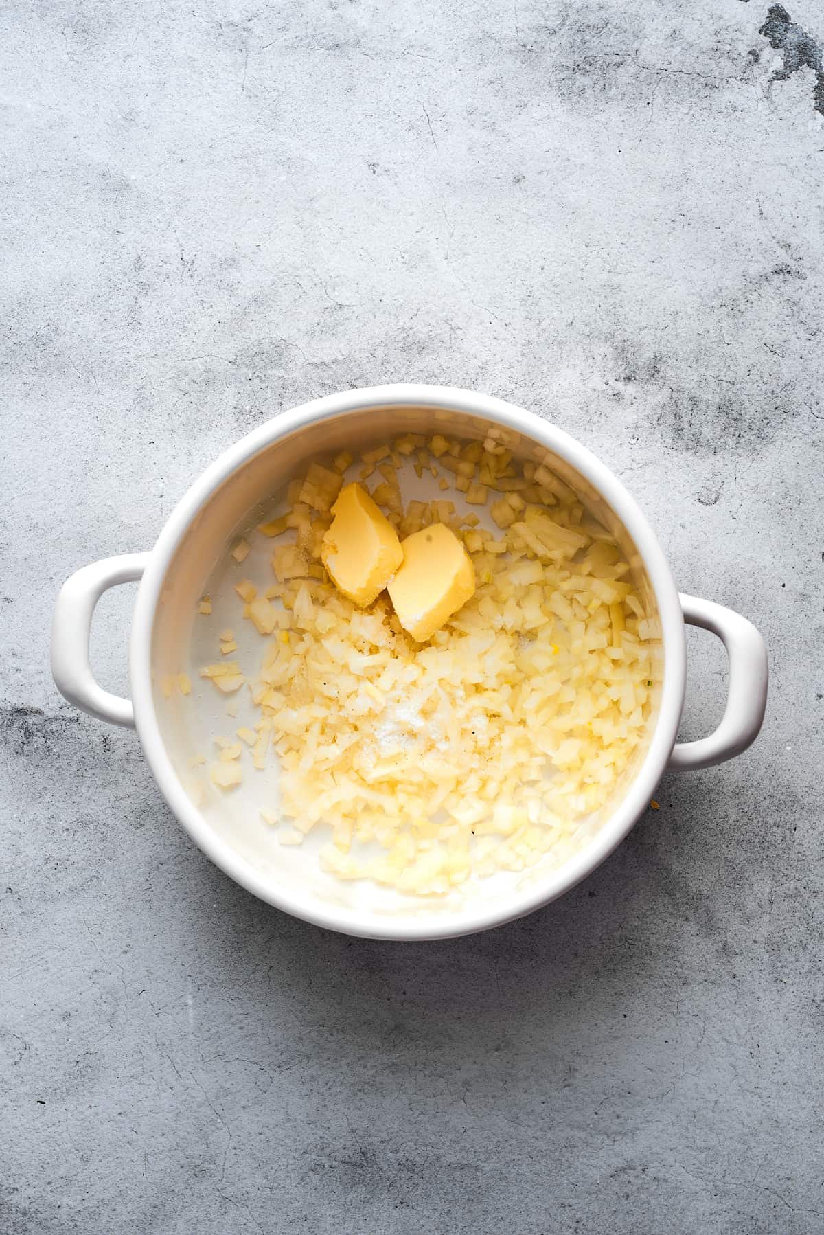 Cooking onions and butter in a soup pot.