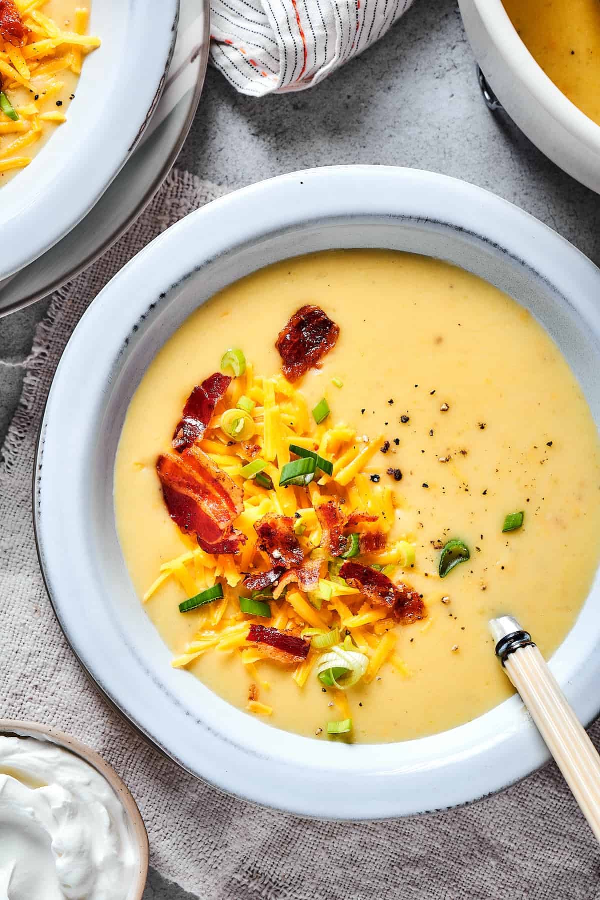 Baked potato soup topped with bacon, cheese, and chopped green onion.