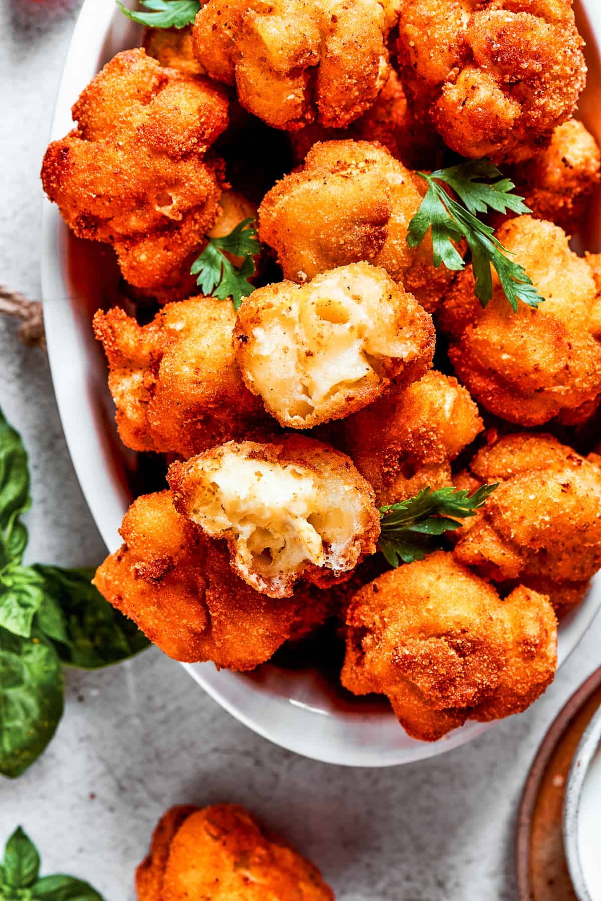 Overhead view of fried mac and cheese bites with one pulled apart.