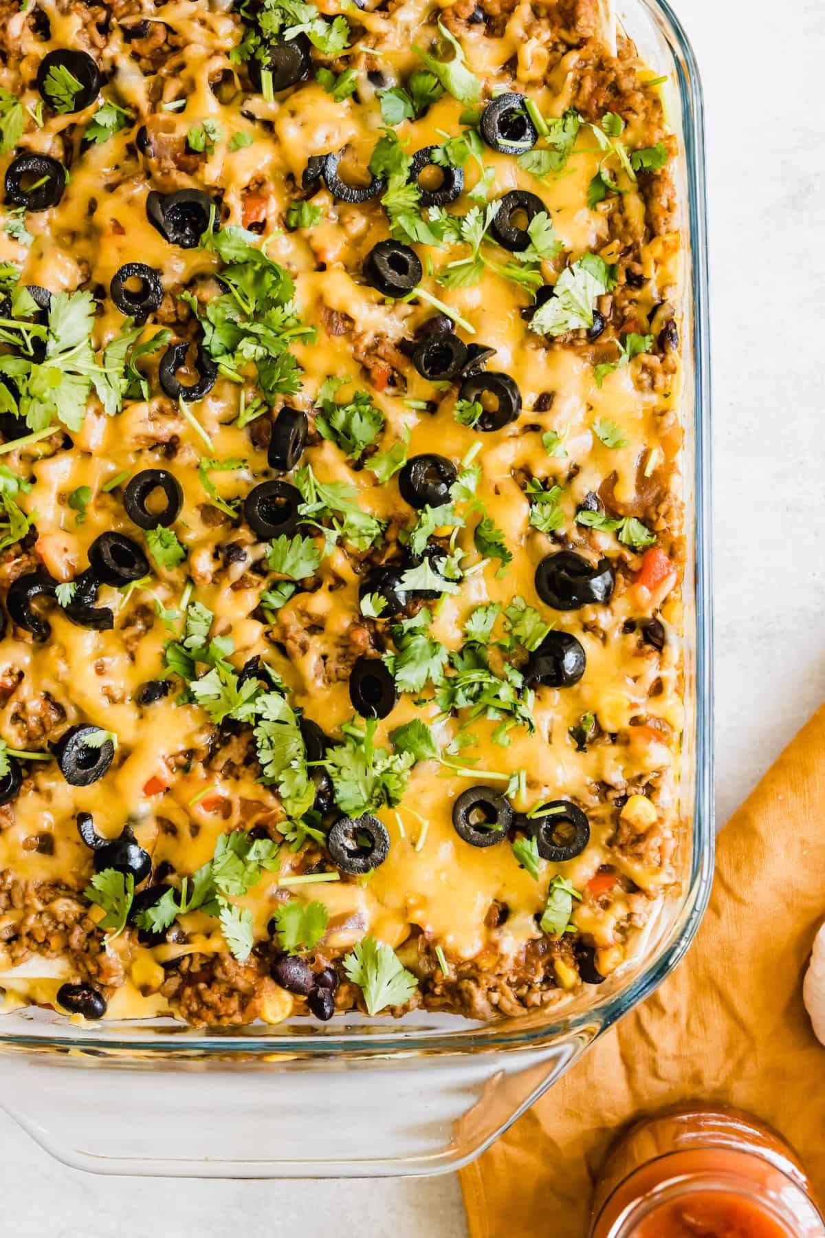 A Glass Casserole Dish Filled with Mexican Lasagna on a Countertop