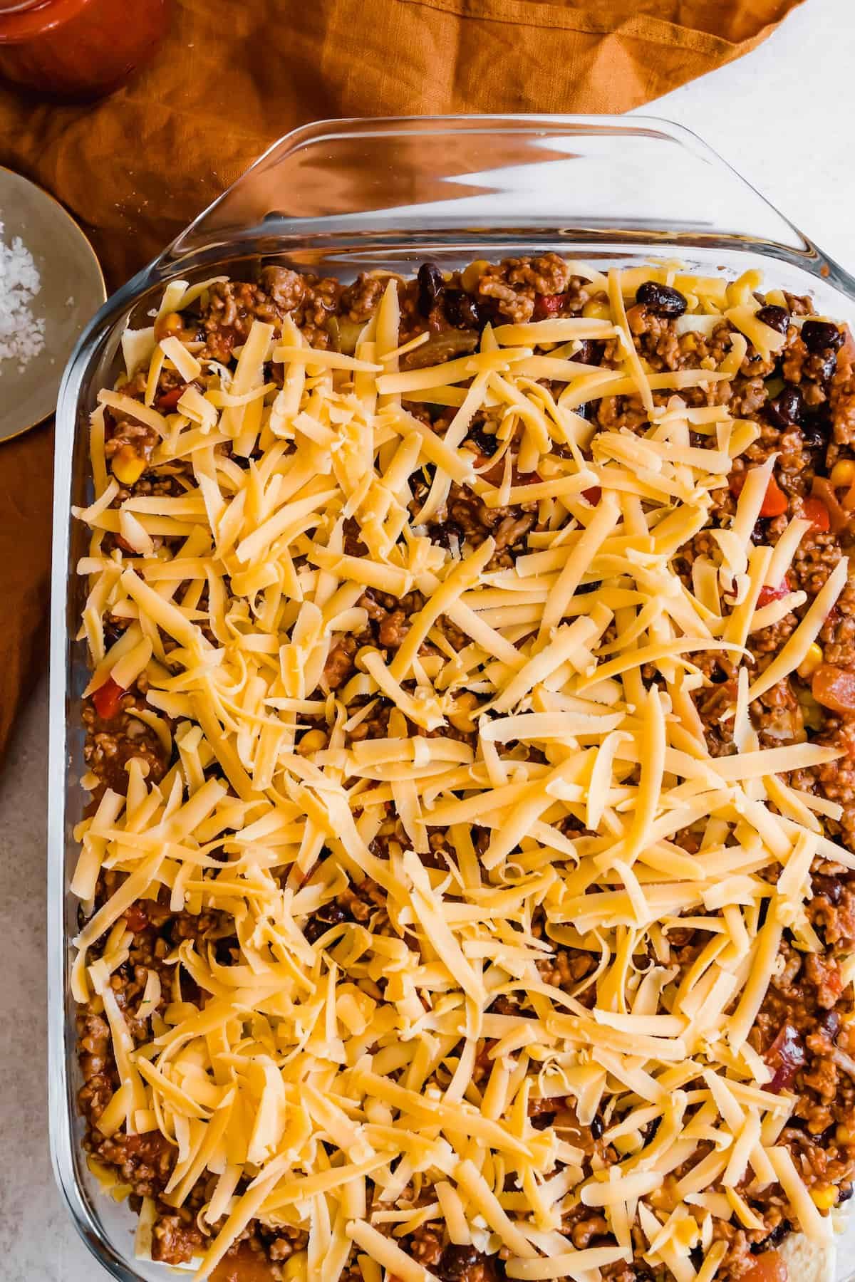 Layered, Unbaked Mexican Lasagna with Shredded Cheddar Cheese on Top