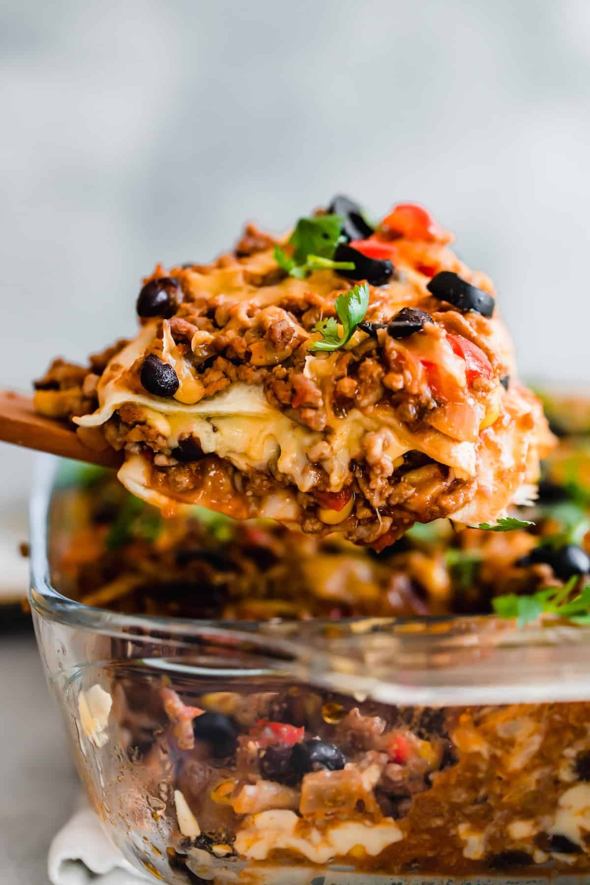 A Scoop of Lasagna Hovering Over the Rest of the Casserole in a Glass Pan