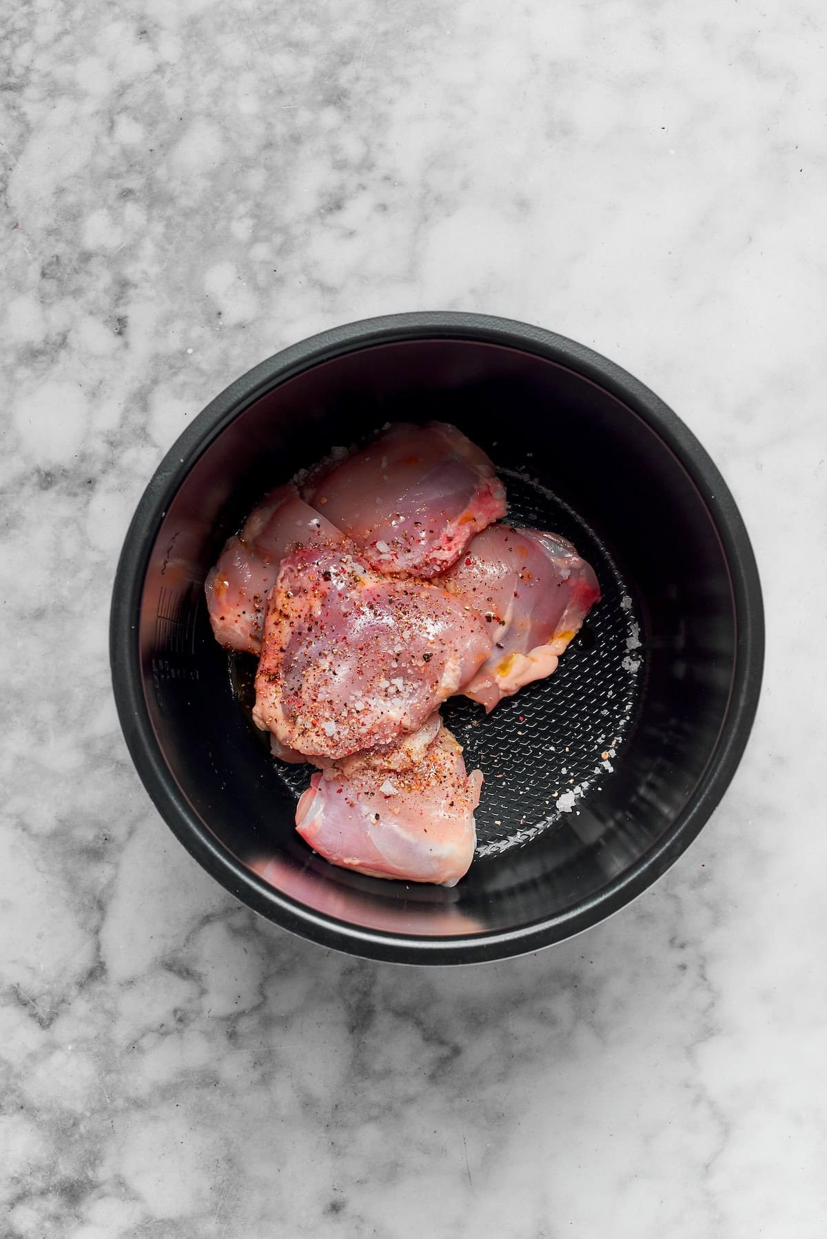 Chicken thighs cook in a pot.