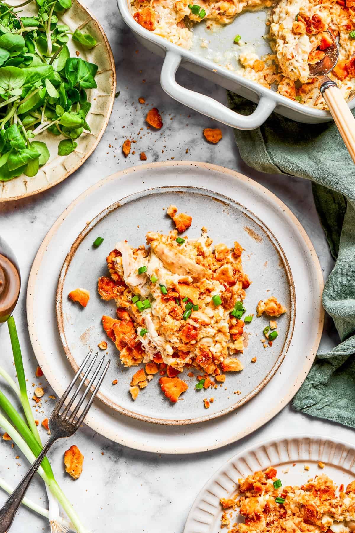 A serving of chicken casserole on a dinner plate with a fork.