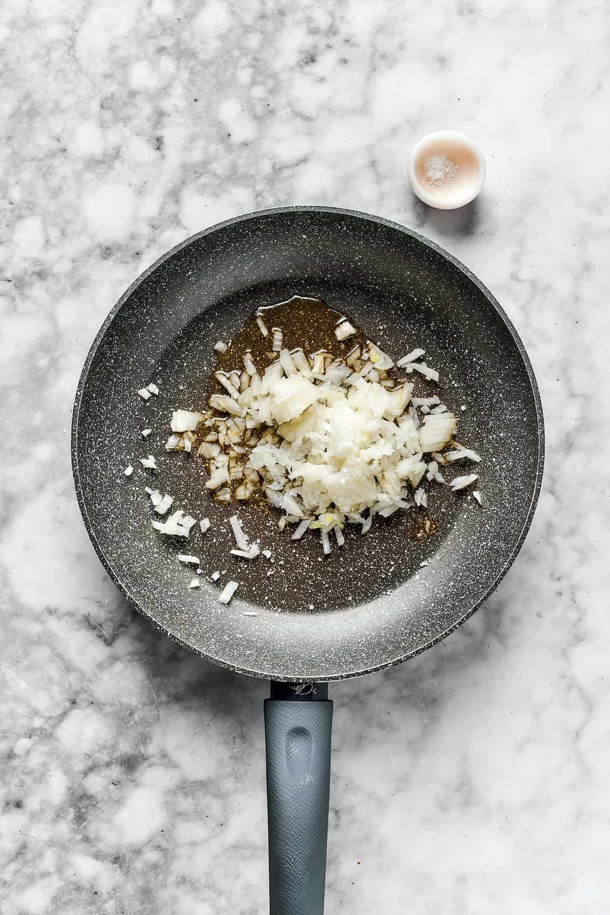 Onions in a skillet ready to cook.