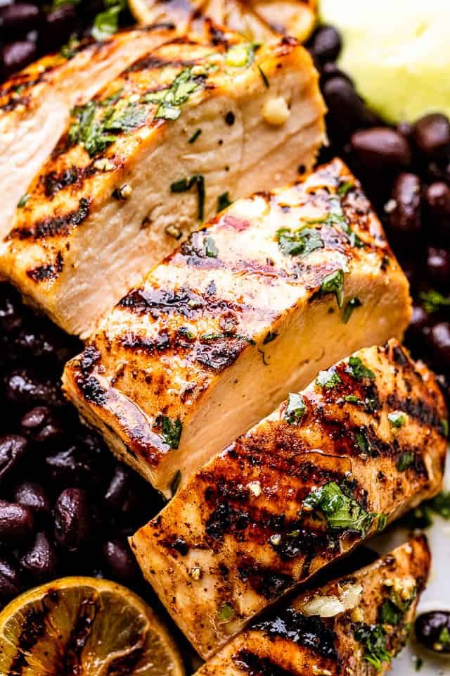 close up view of mojo chicken with black beans under it