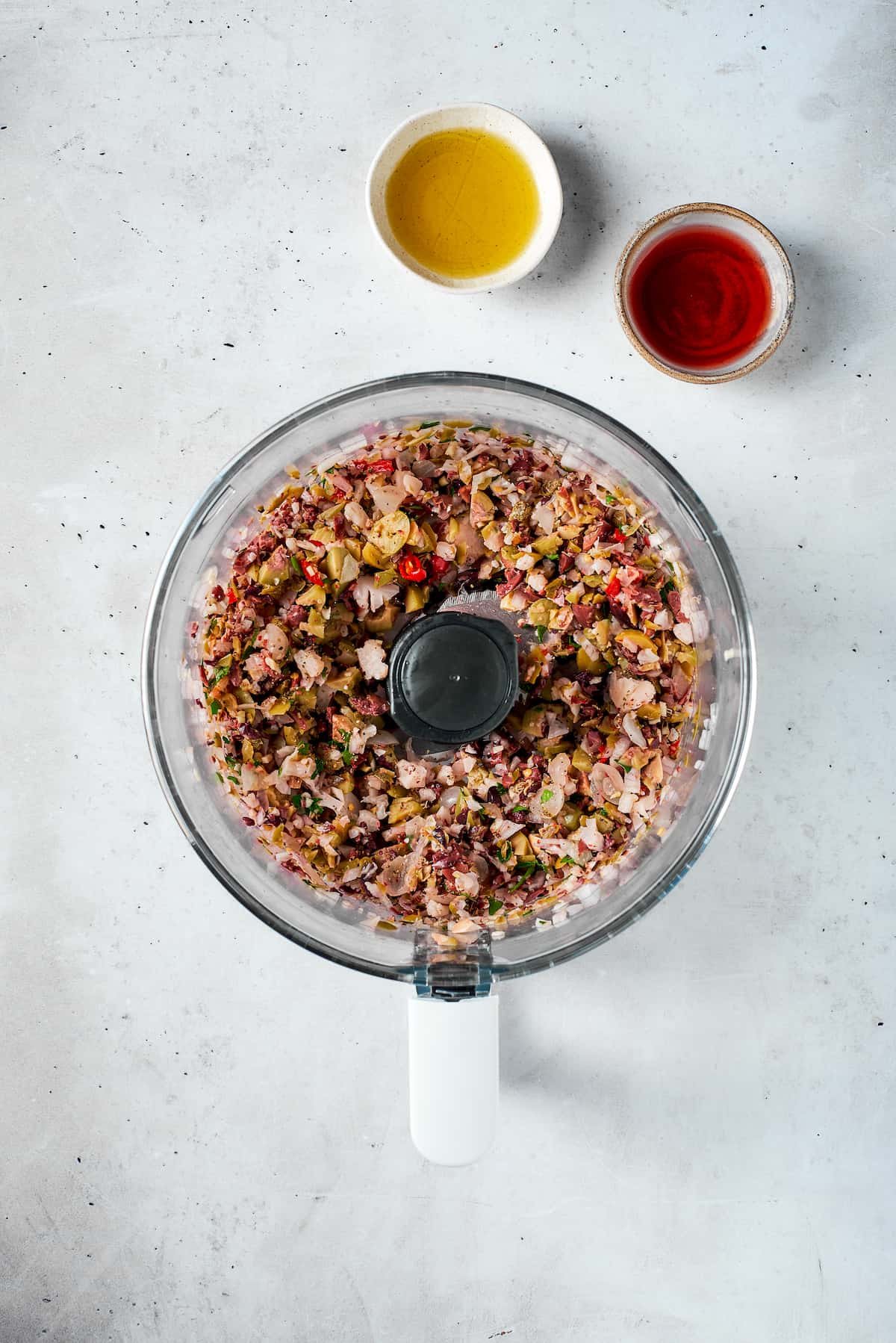 The olive salad is finely blended in a food processor.