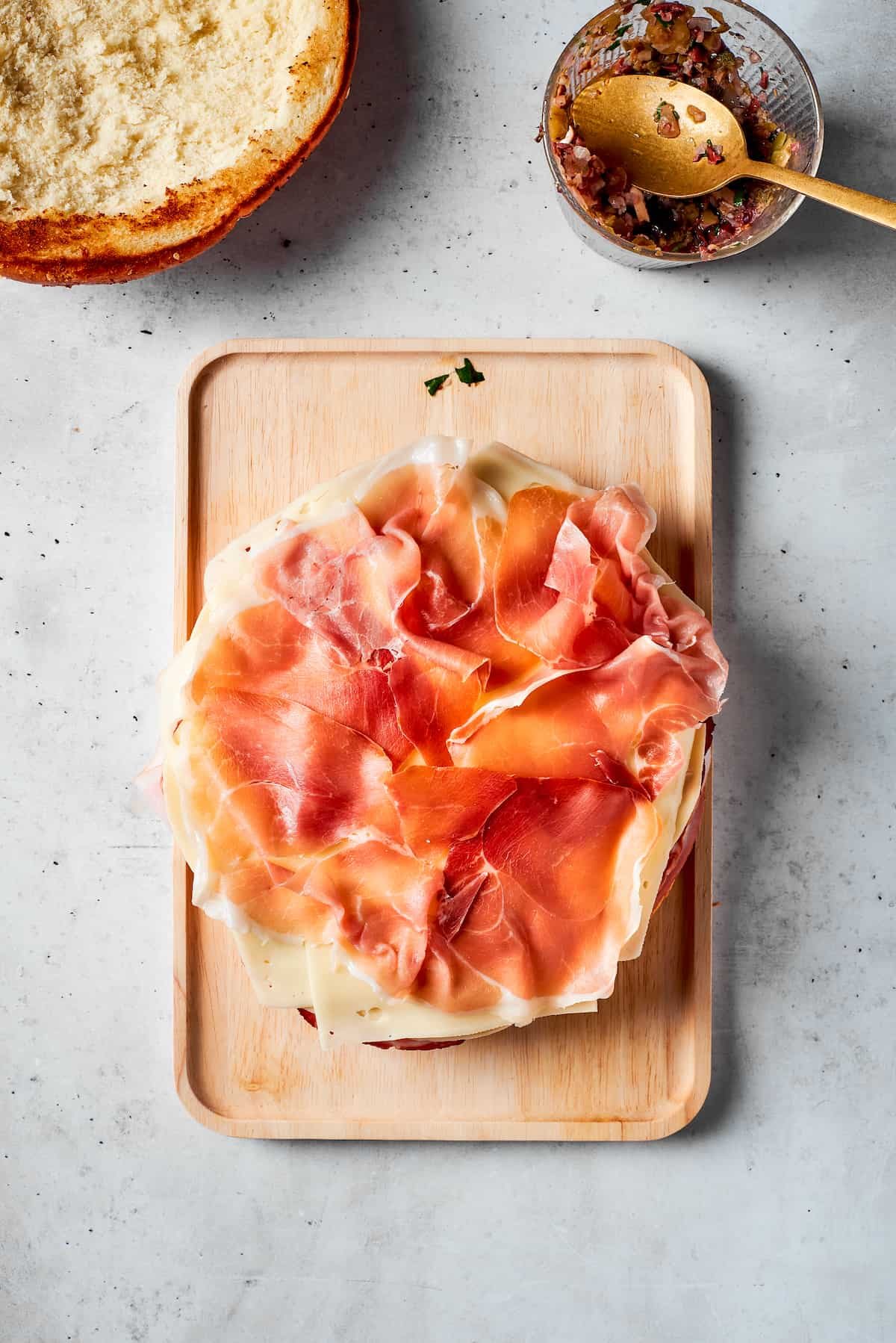 Prosciutto is added to the sandwich.