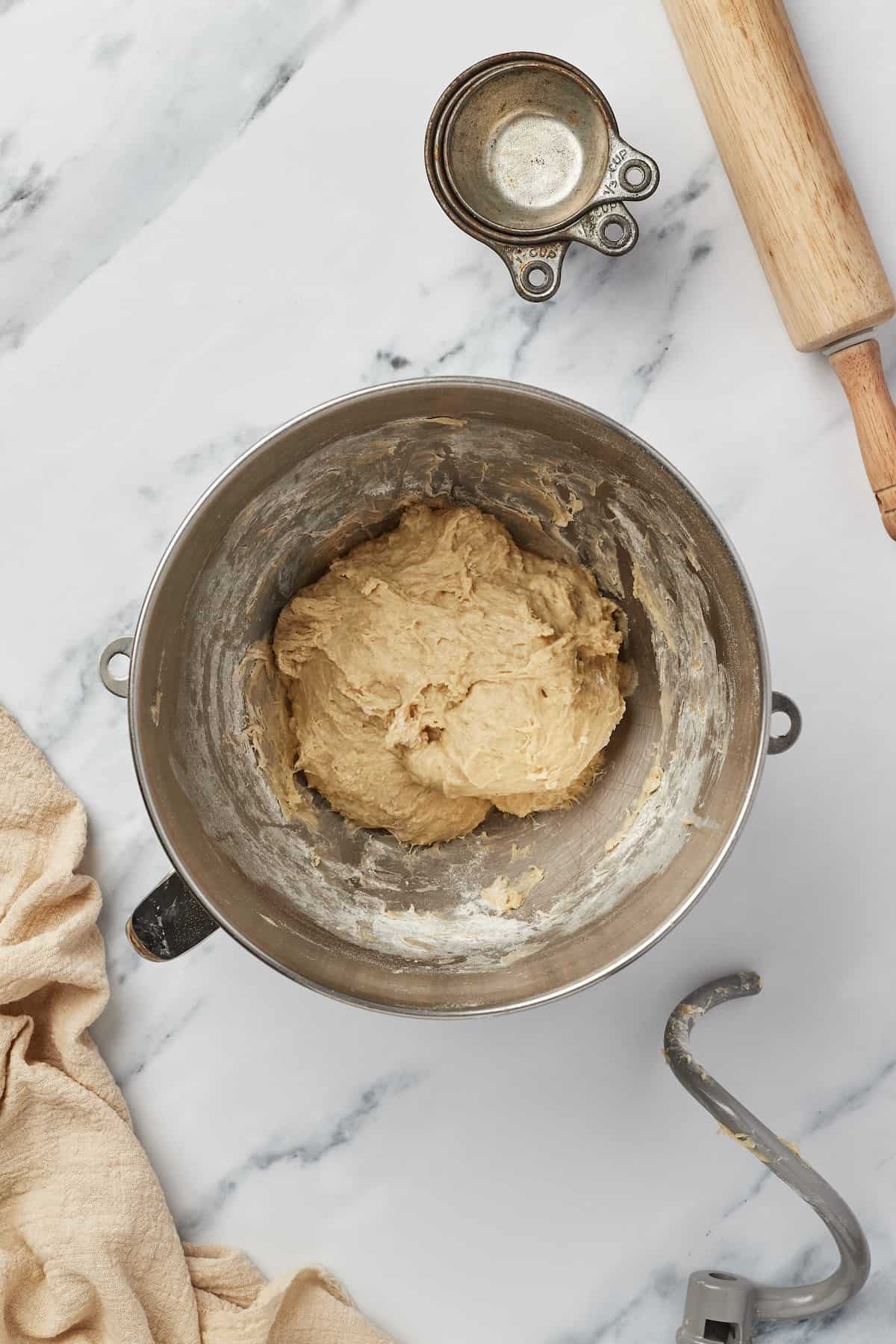 A soft dough in the bowl of a stand mixer.