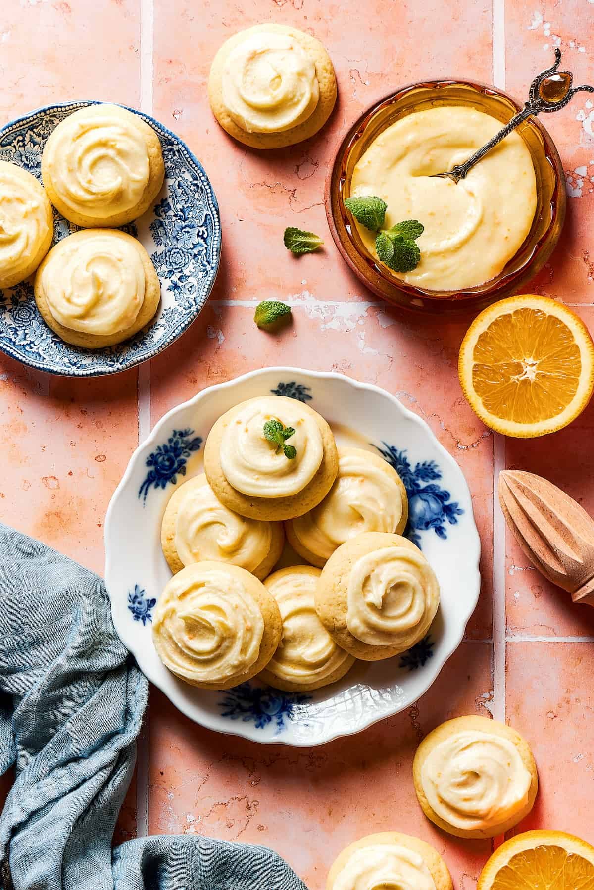 A platter of iced cookies with more cookies on a small saucer.
