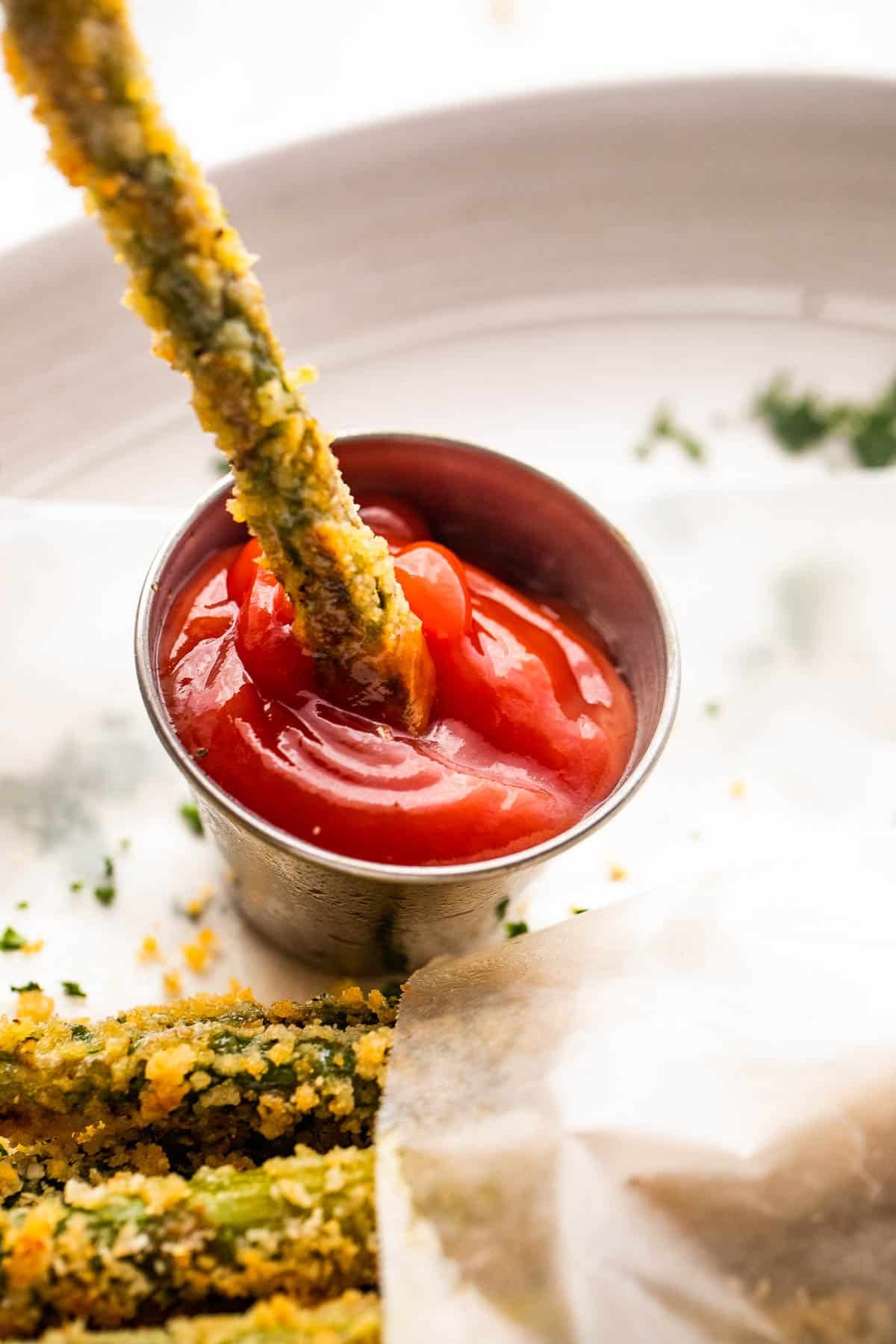 dipping asparagus fries in ketchup
