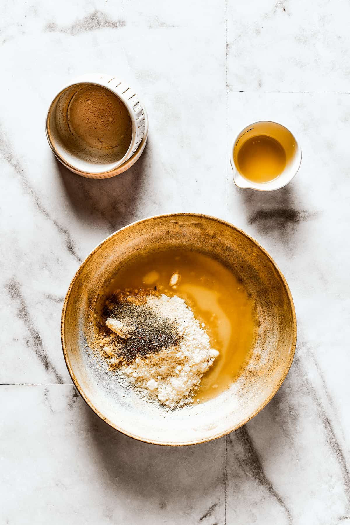 Seasonings, parmesan, and butter in a shallow dish.