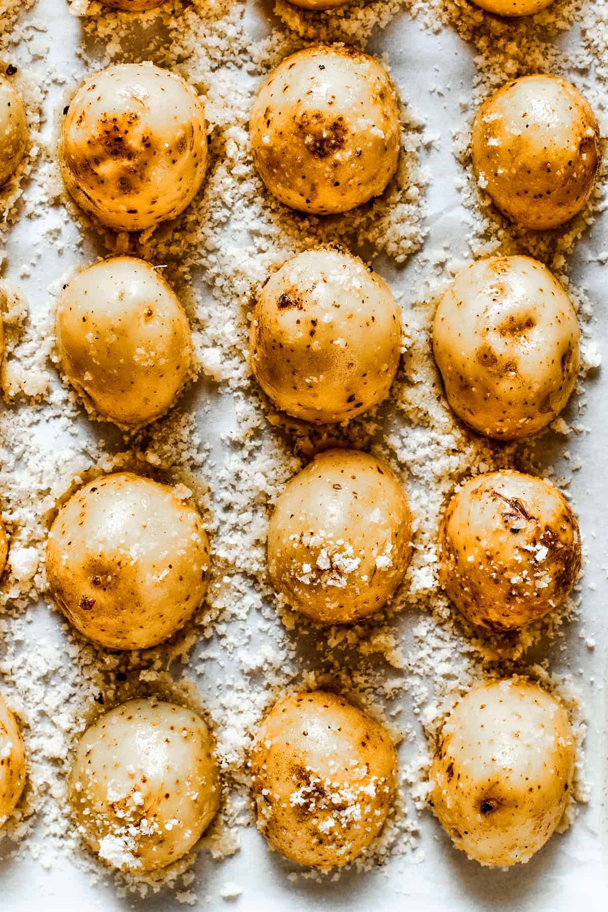 Close-up of baked parmesan-crusted potatoes in a baking dish.
