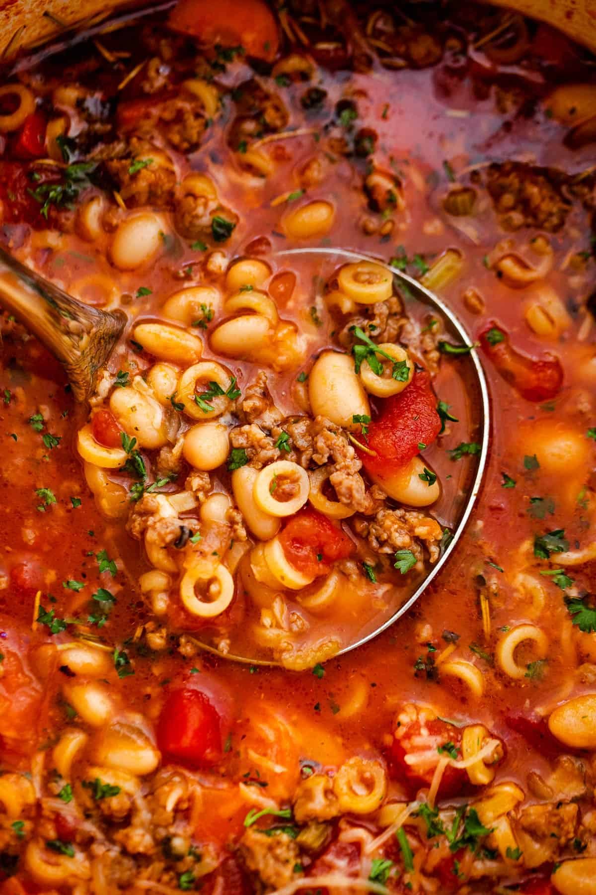 up close shot of a ladle spooning out pasta fagioli soup
