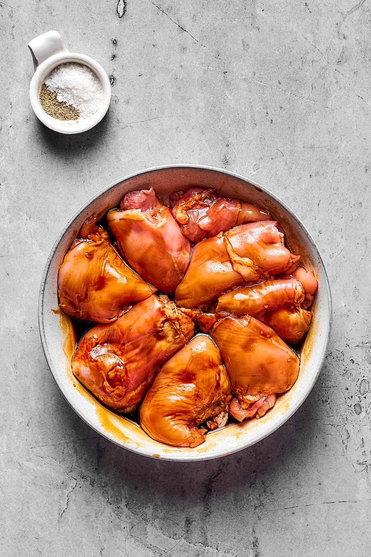 Boneless, skinless chicken thighs marinating in soy sauce.