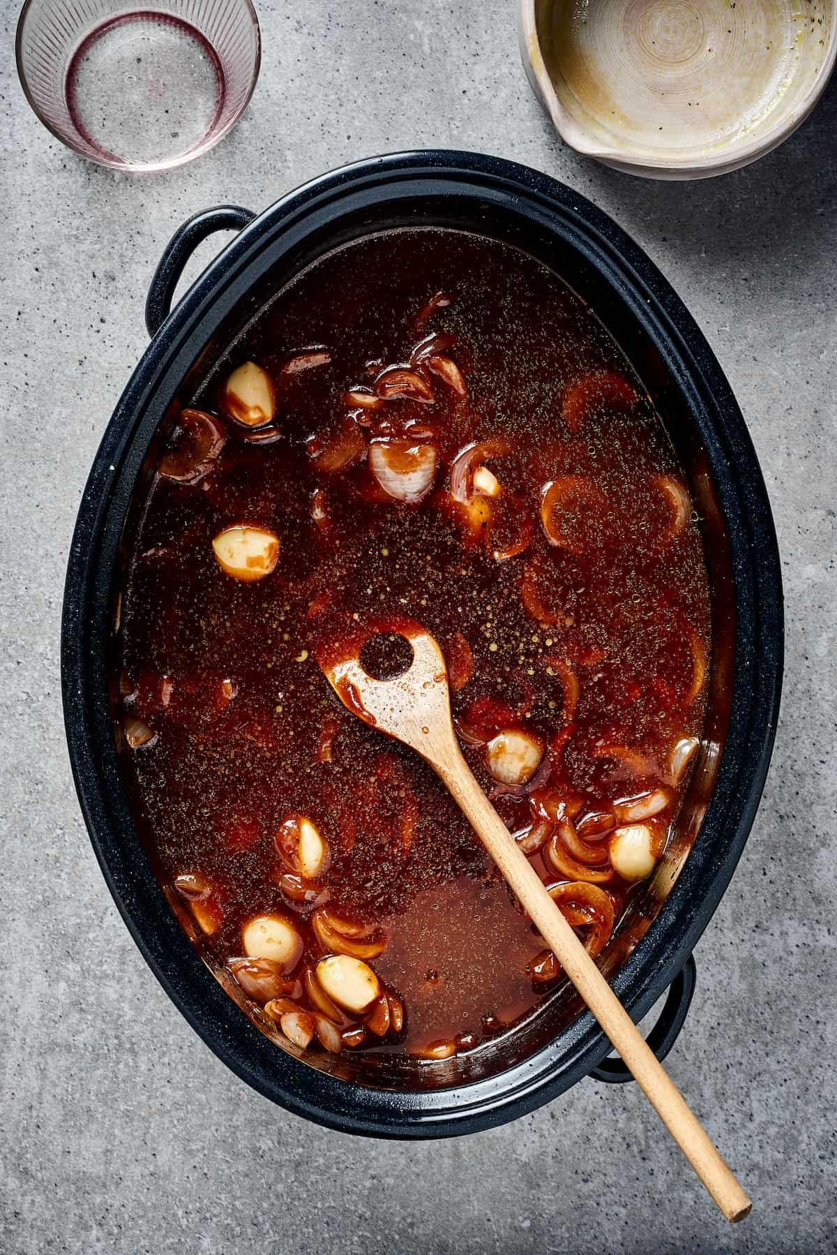 A Dutch oven filled with a beef-broth-based sauce.