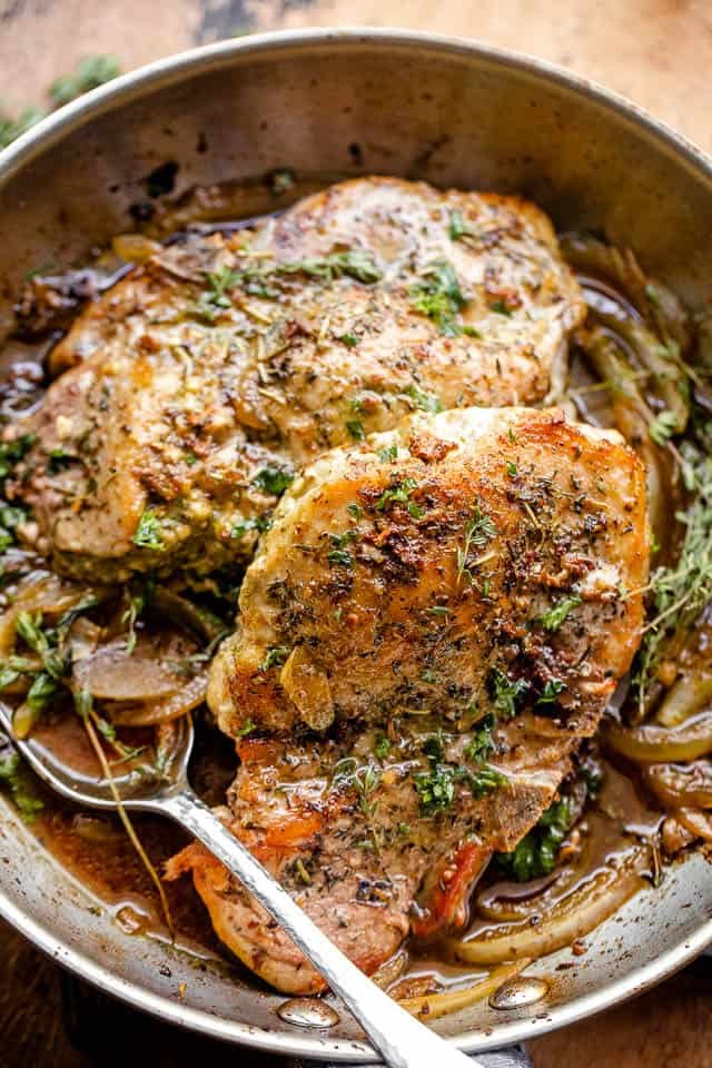overhead close-up shot of pesto stuffed pork chops in a skillet