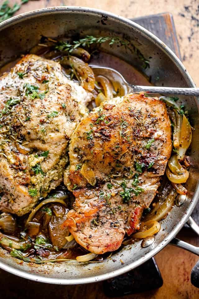 overhead shot of pesto stuffed pork chops in a skillet