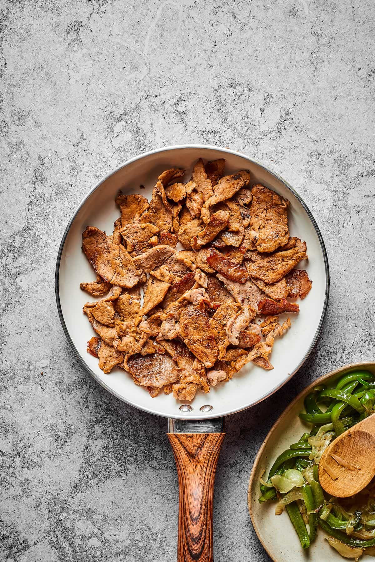 Steak strips cooking in a skillet.