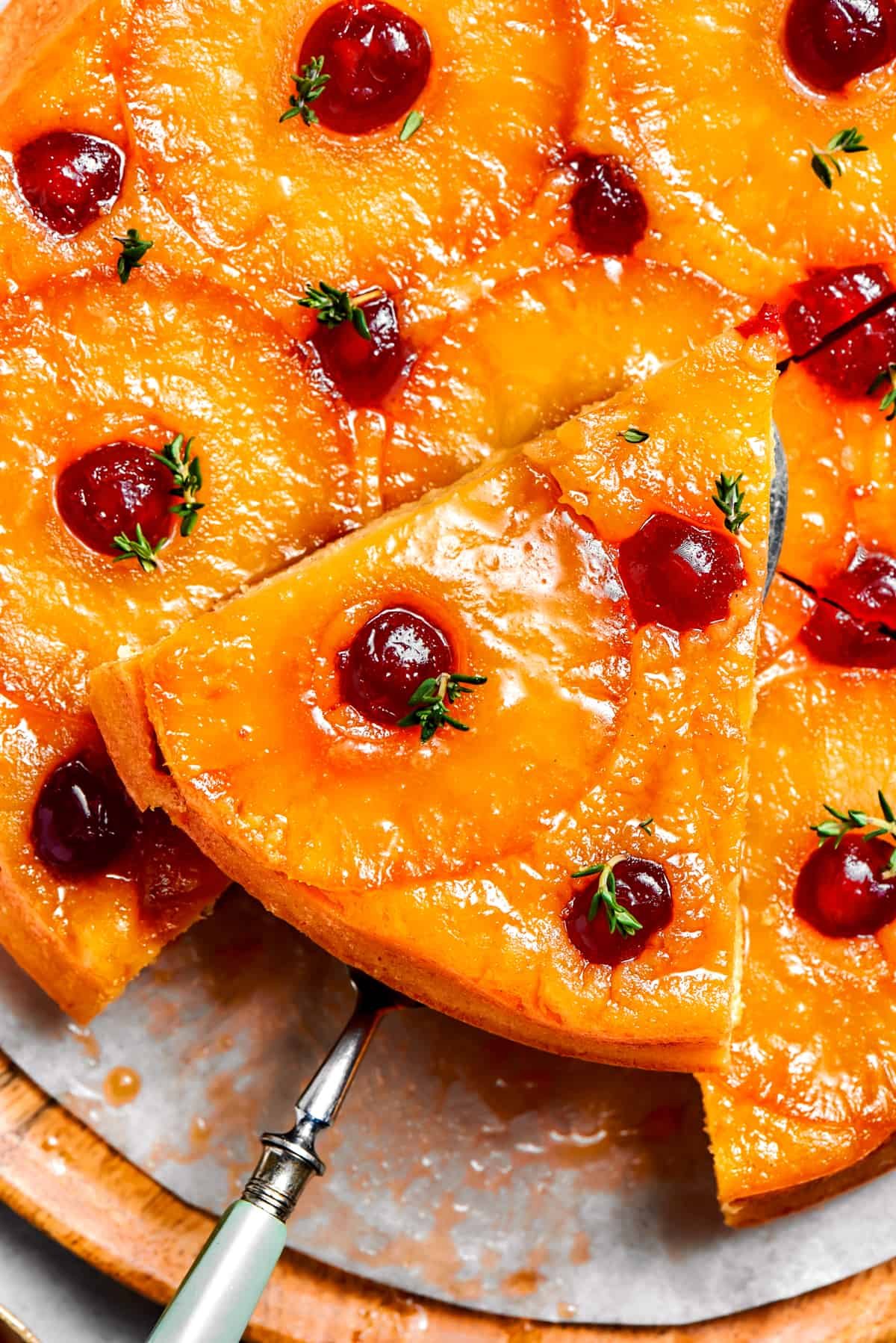 Pineapple Cake topped with pineapple rings and maraschino cherries, with a cake served pulling out a slice.