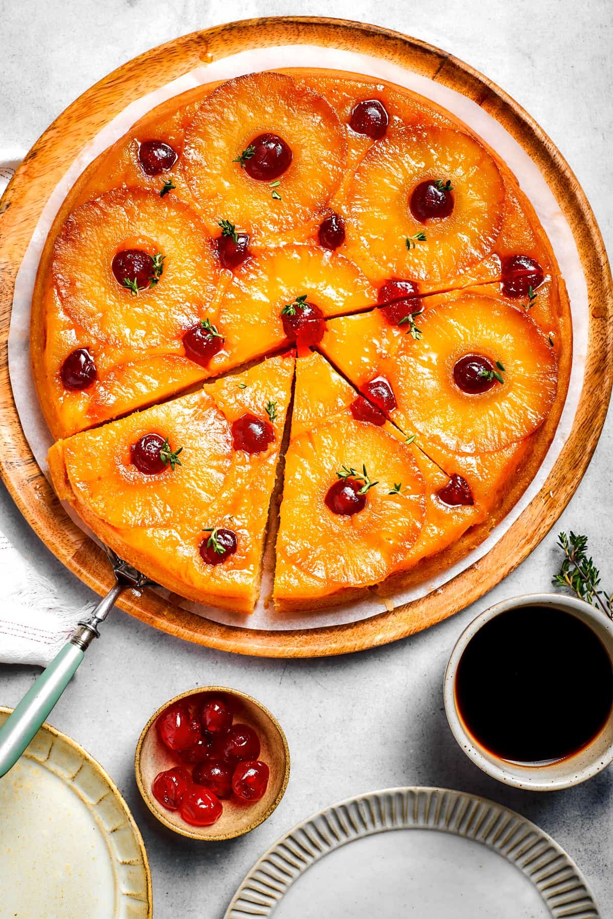 A round cake topped with pineapple rings and maraschino cherries.