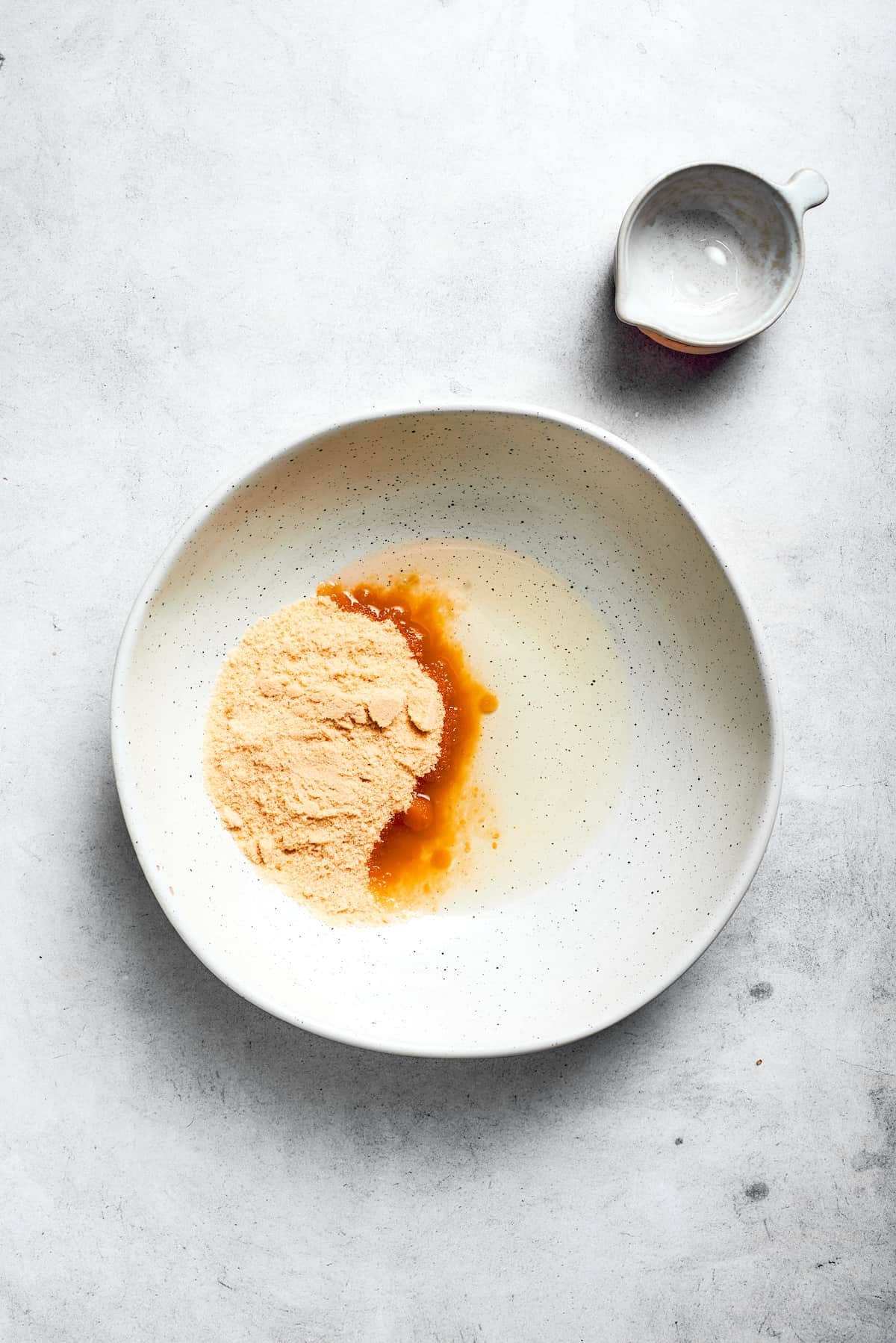 Oil and sugar are added to a bowl.