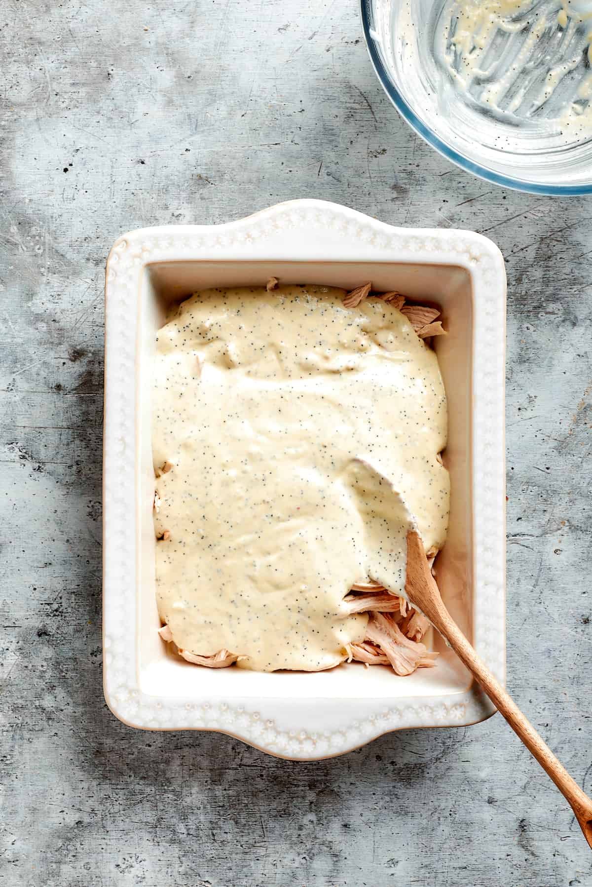 Sauce is spread over the chicken.