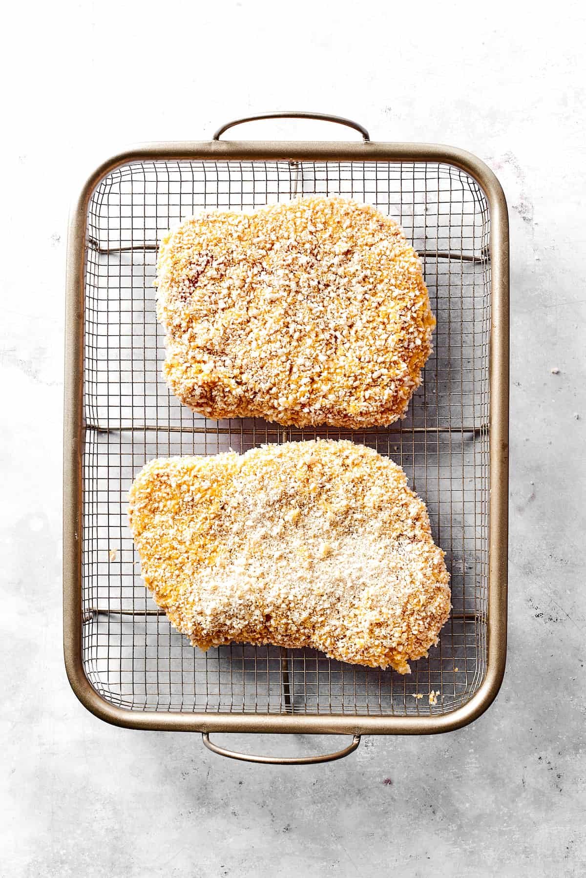 Breaded pork arranged on a wire rack.