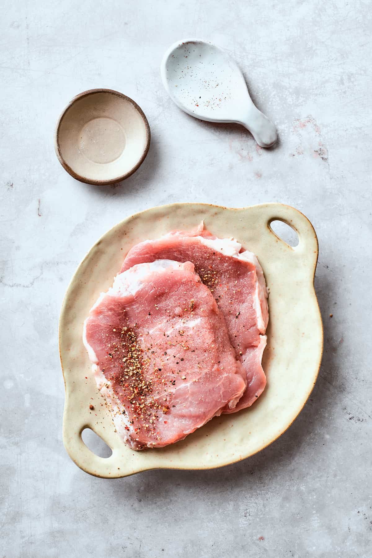 Pork cutlets seasoned with salt and pepper.