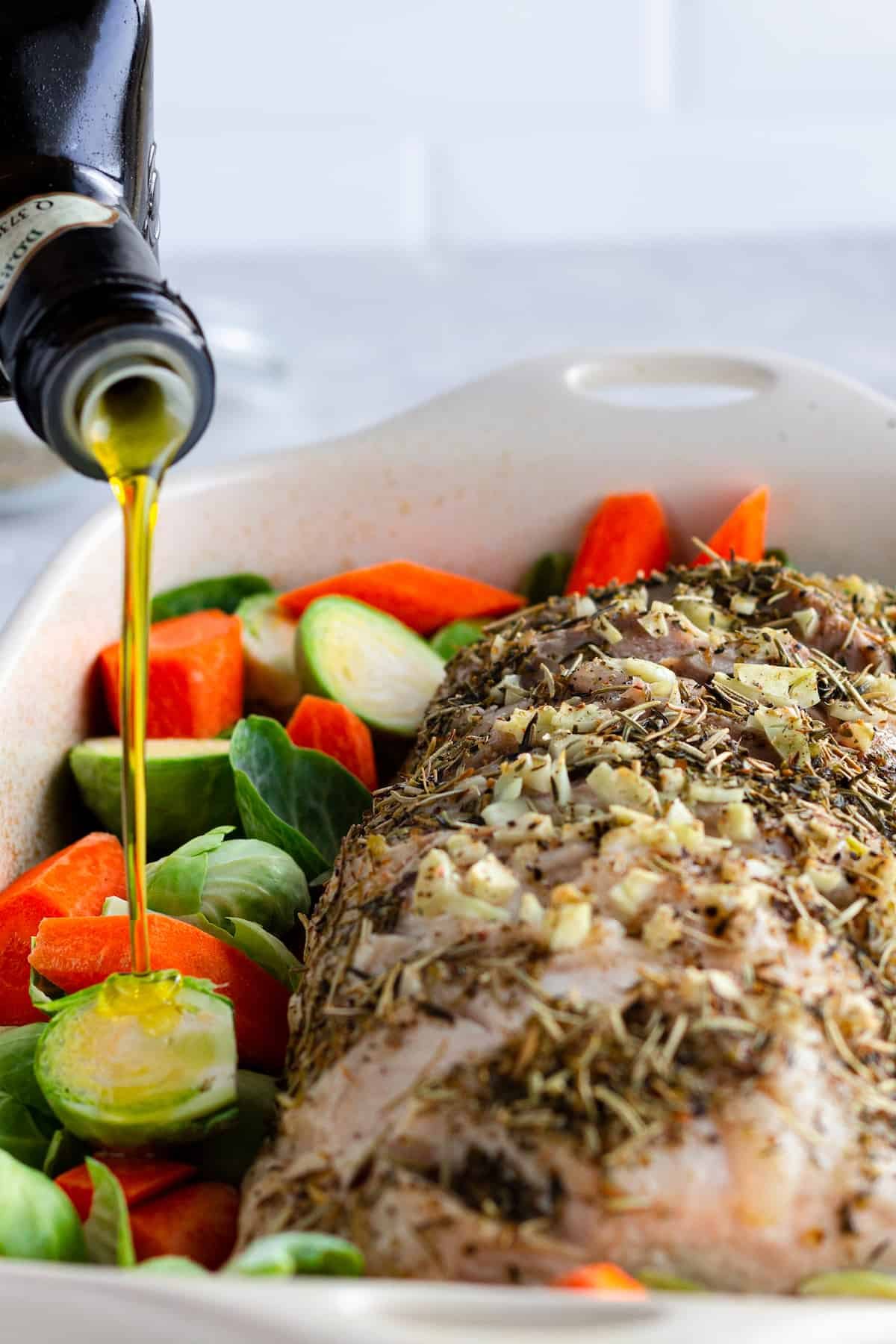Olive Oil Being Drizzled Over the Raw Veggies in the Casserole Dish