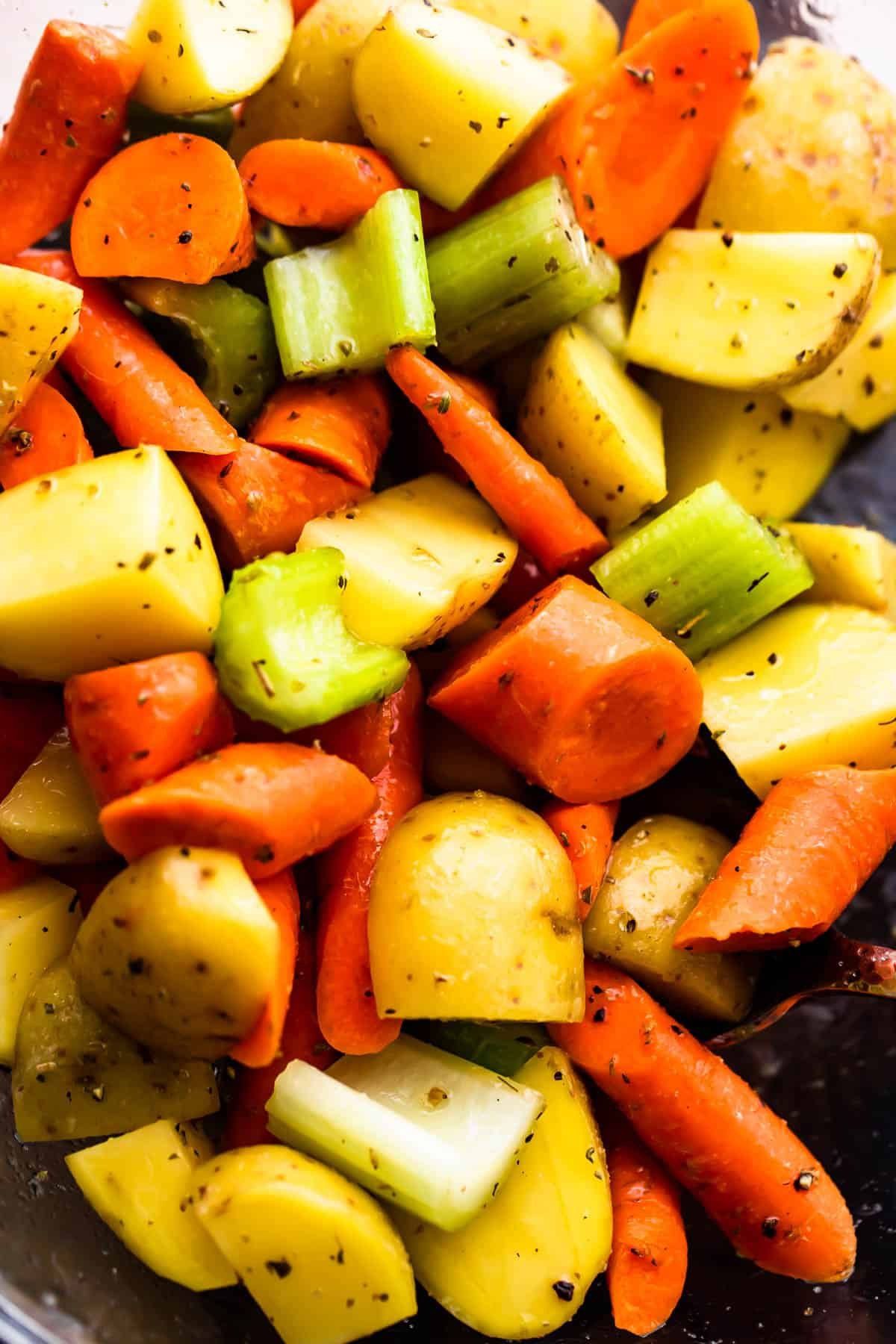 glass bowl with chopped pieces of carrots, celery, and potatoes