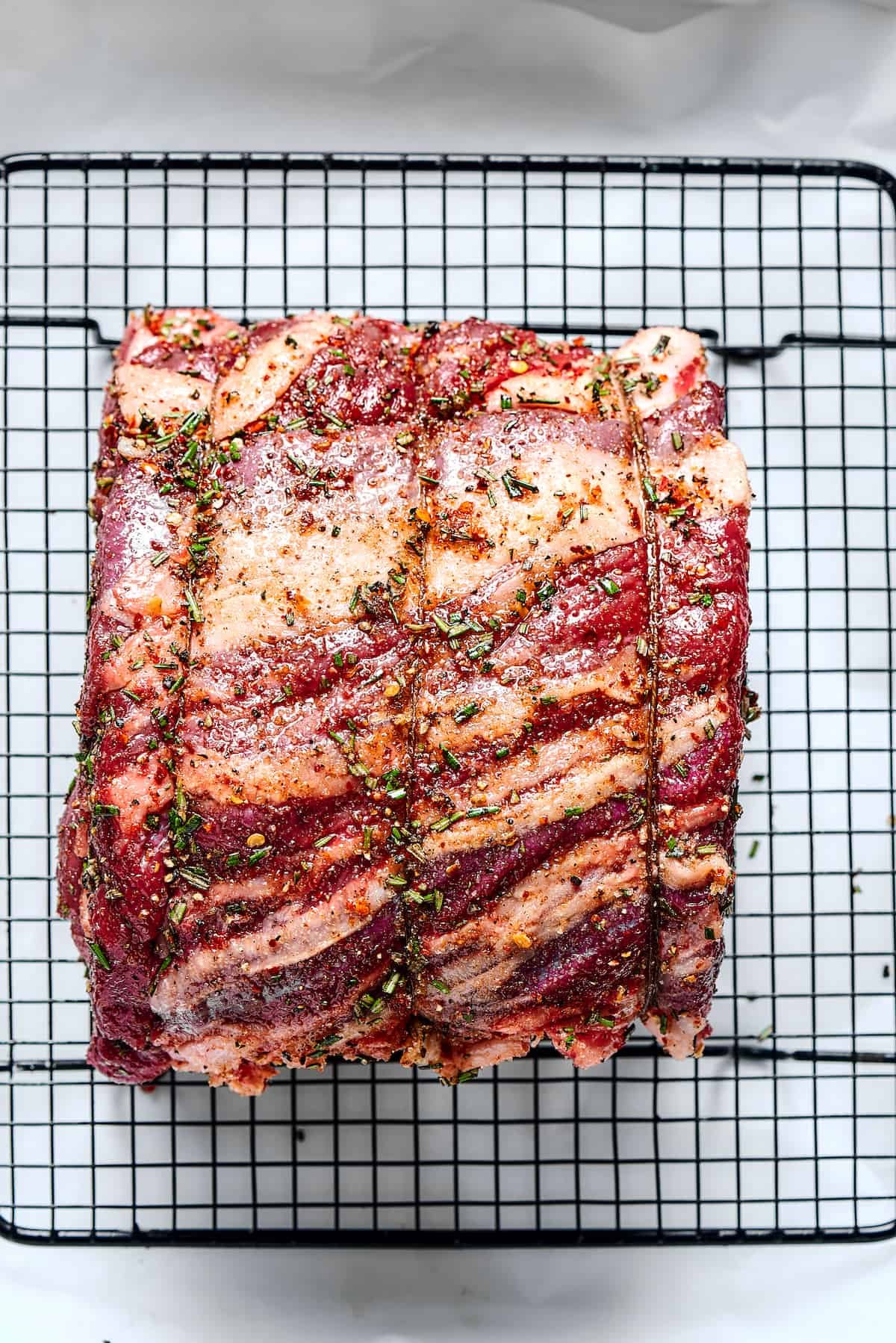 Setting a tied rib roast on a roasting rack.