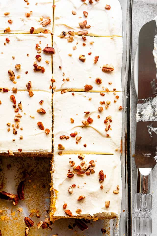 overhead shot of cream cheese frosted pumpkin cake sprinkled with chopped pecans