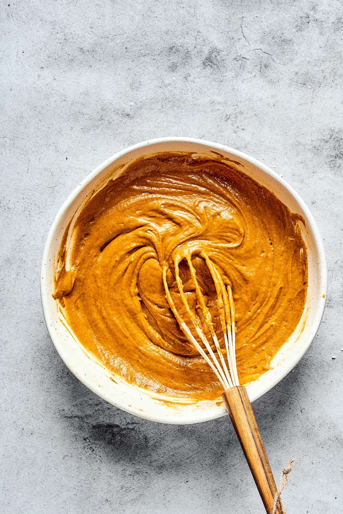 Pumpkin muffin batter in a mixing bowl.