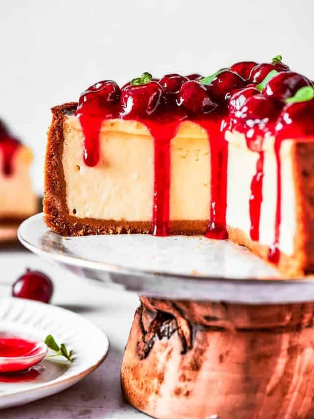 Cherry cheesecake on a cake stand.