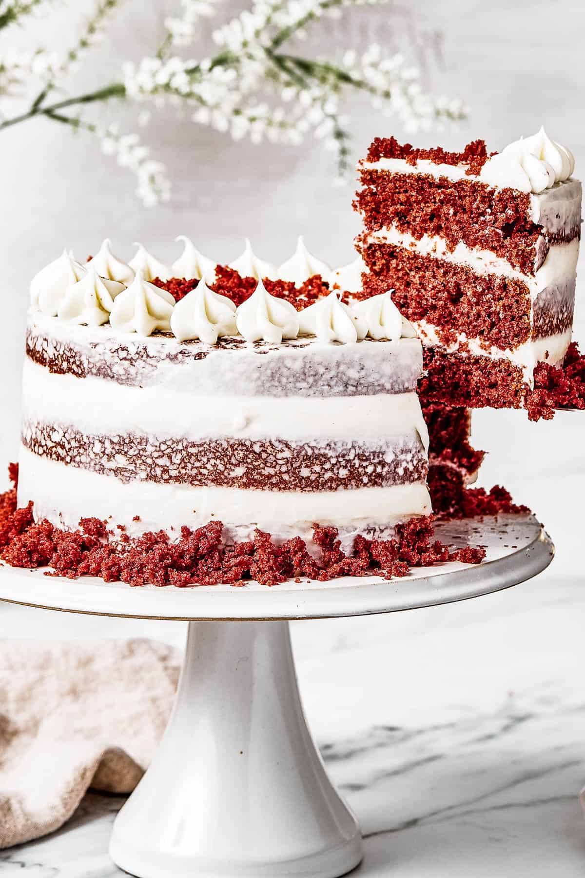 A woman's hand is lifting a slice of cake on a serving utensil.