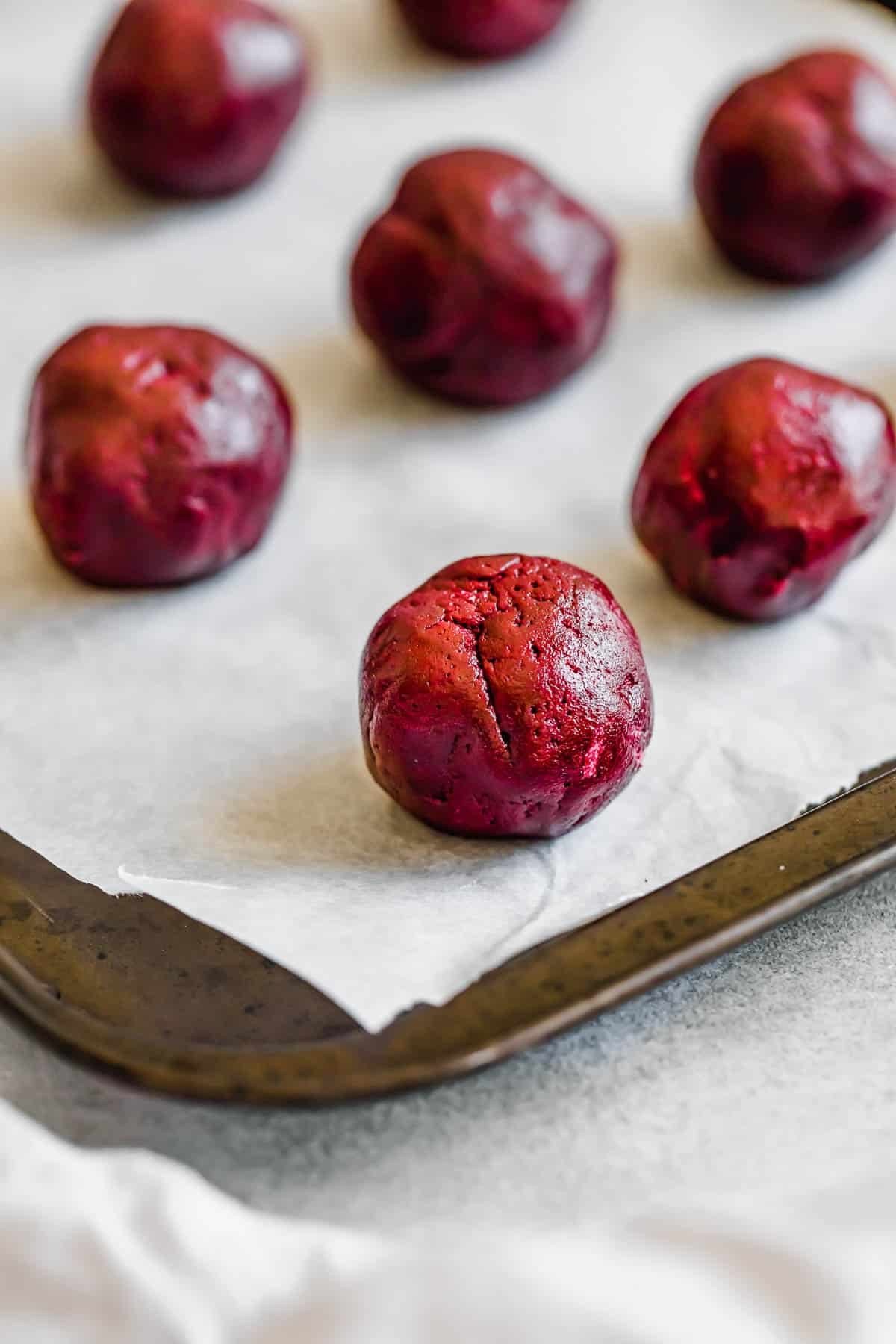 A Ball of Red Velvet Cookie Dough Coated in Granulated Sugar