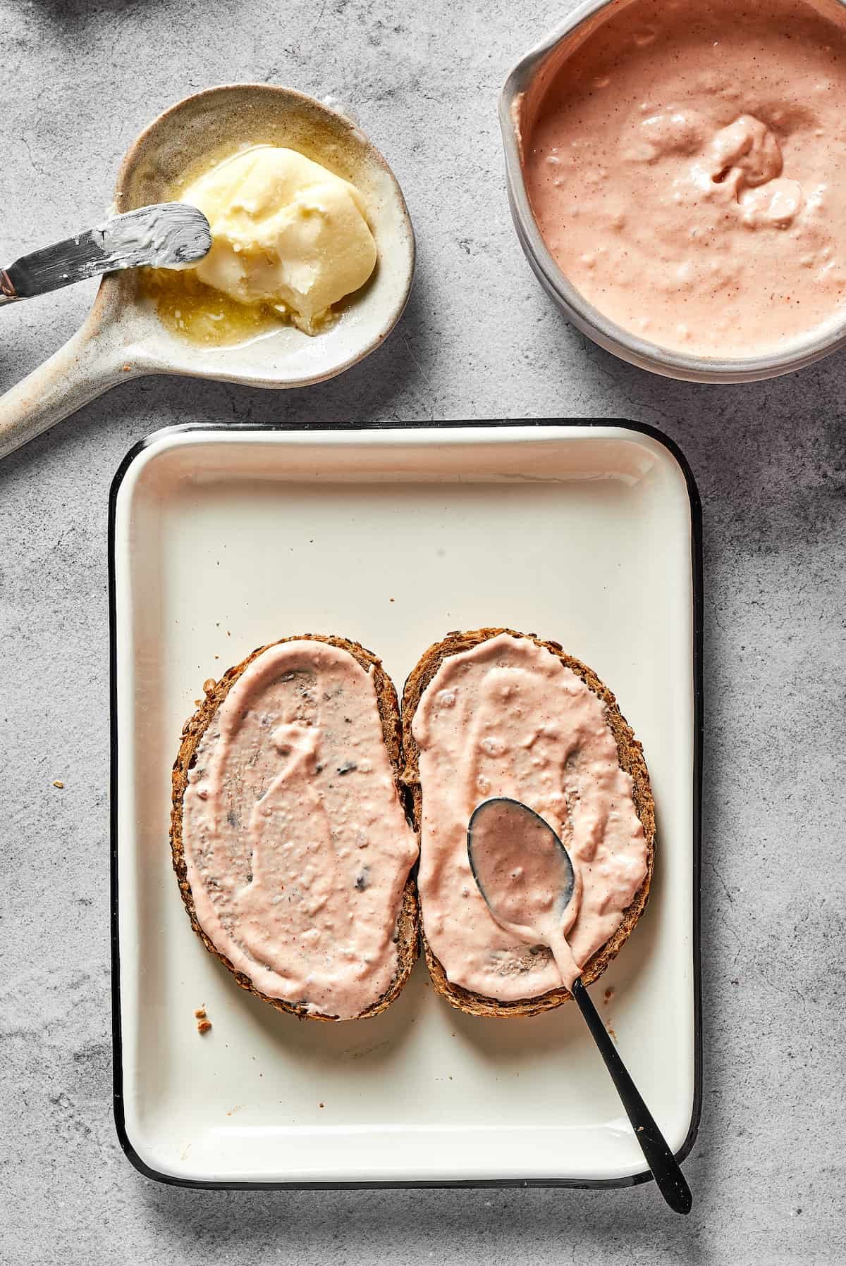 Spreading Russian dressing thickly on bread.