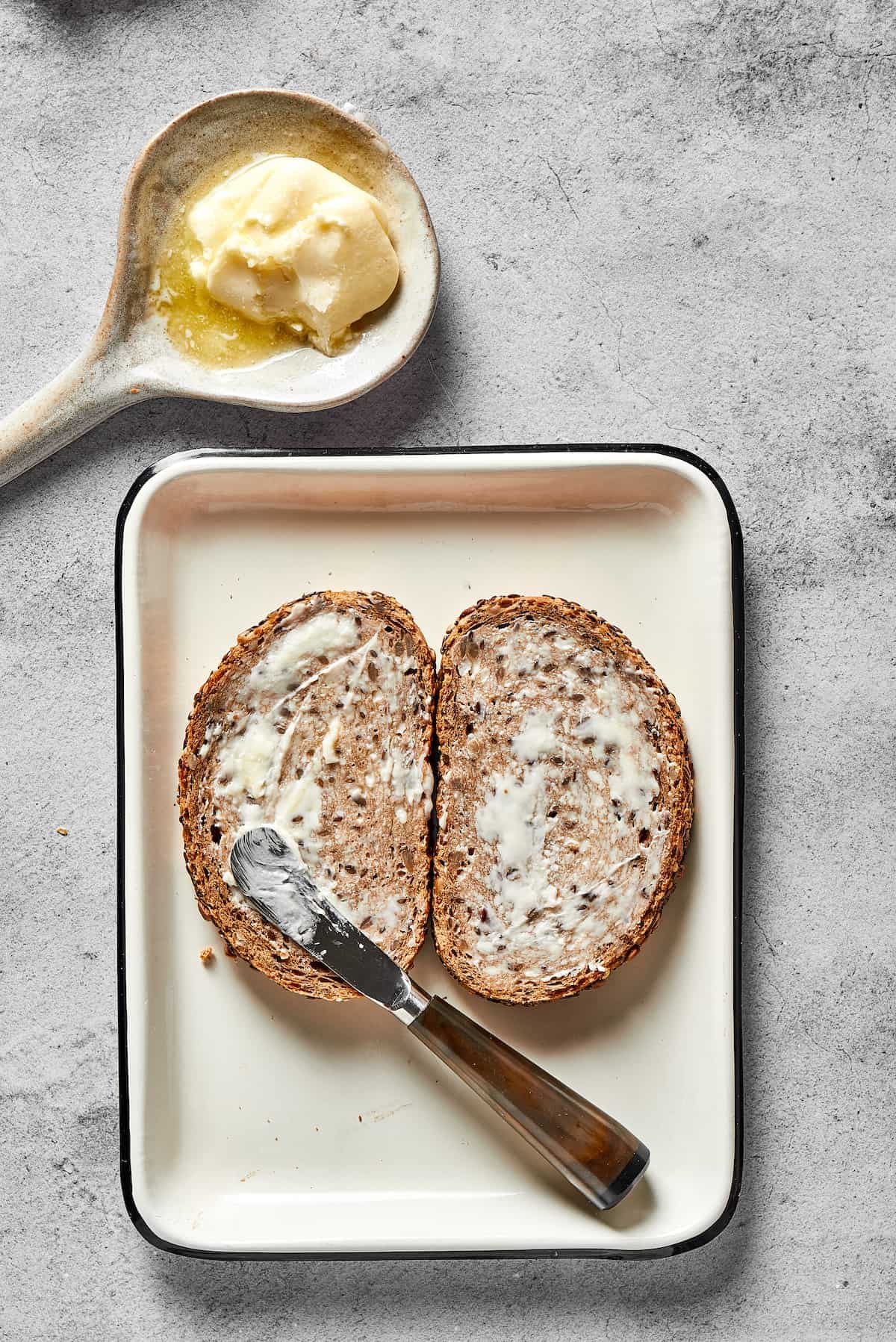 Spreading butter thinly on bread.