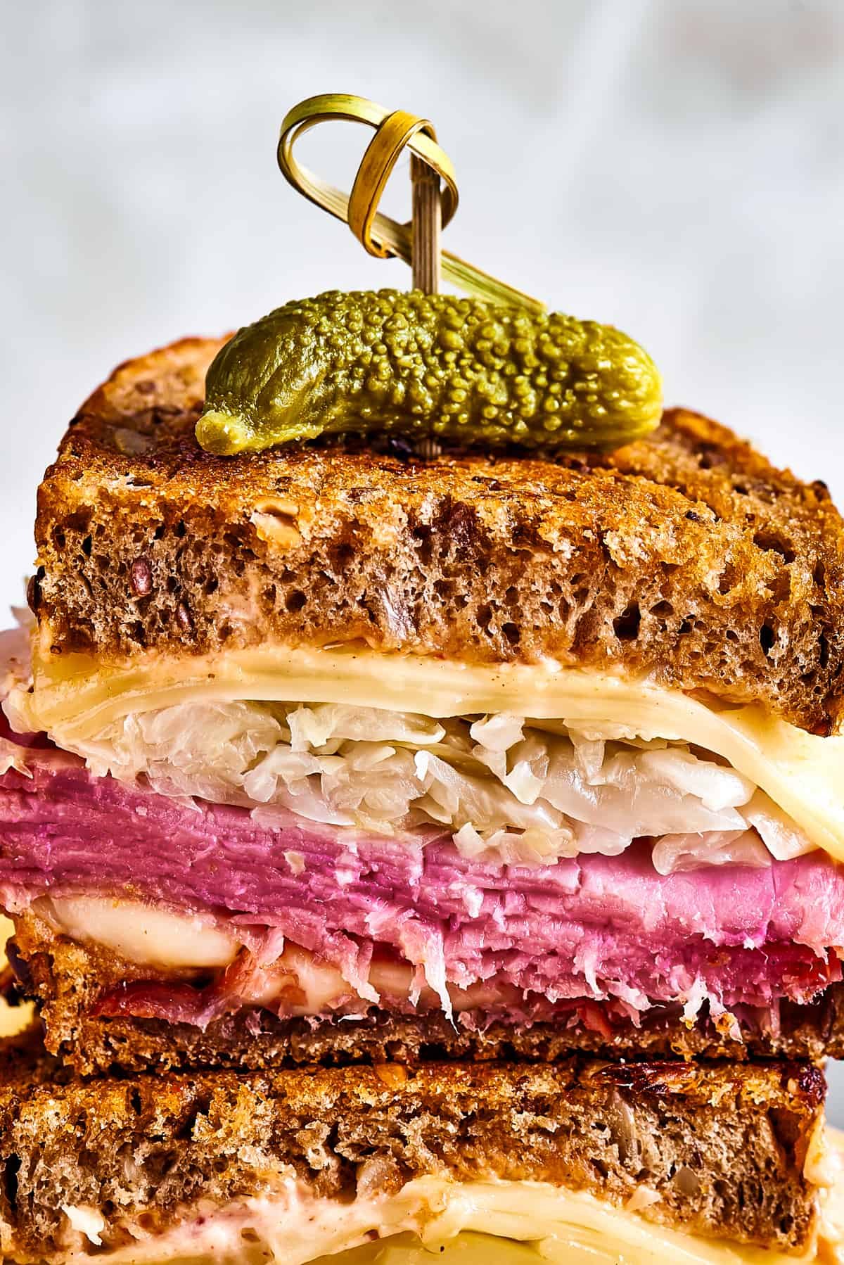 A pair of stacked sandwich halves held together with a decorative skewer.