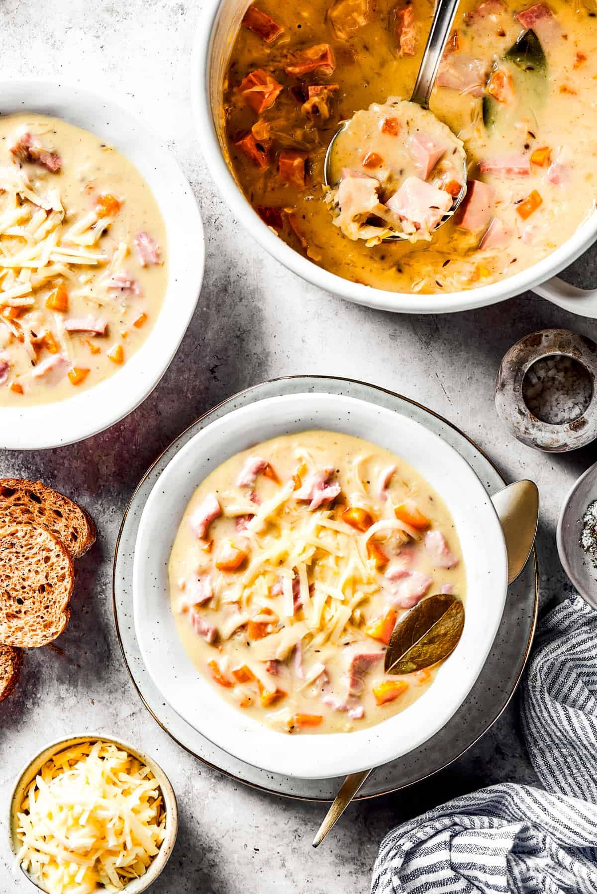 A pot of Reuben soup with two bowls of the soup next to it.